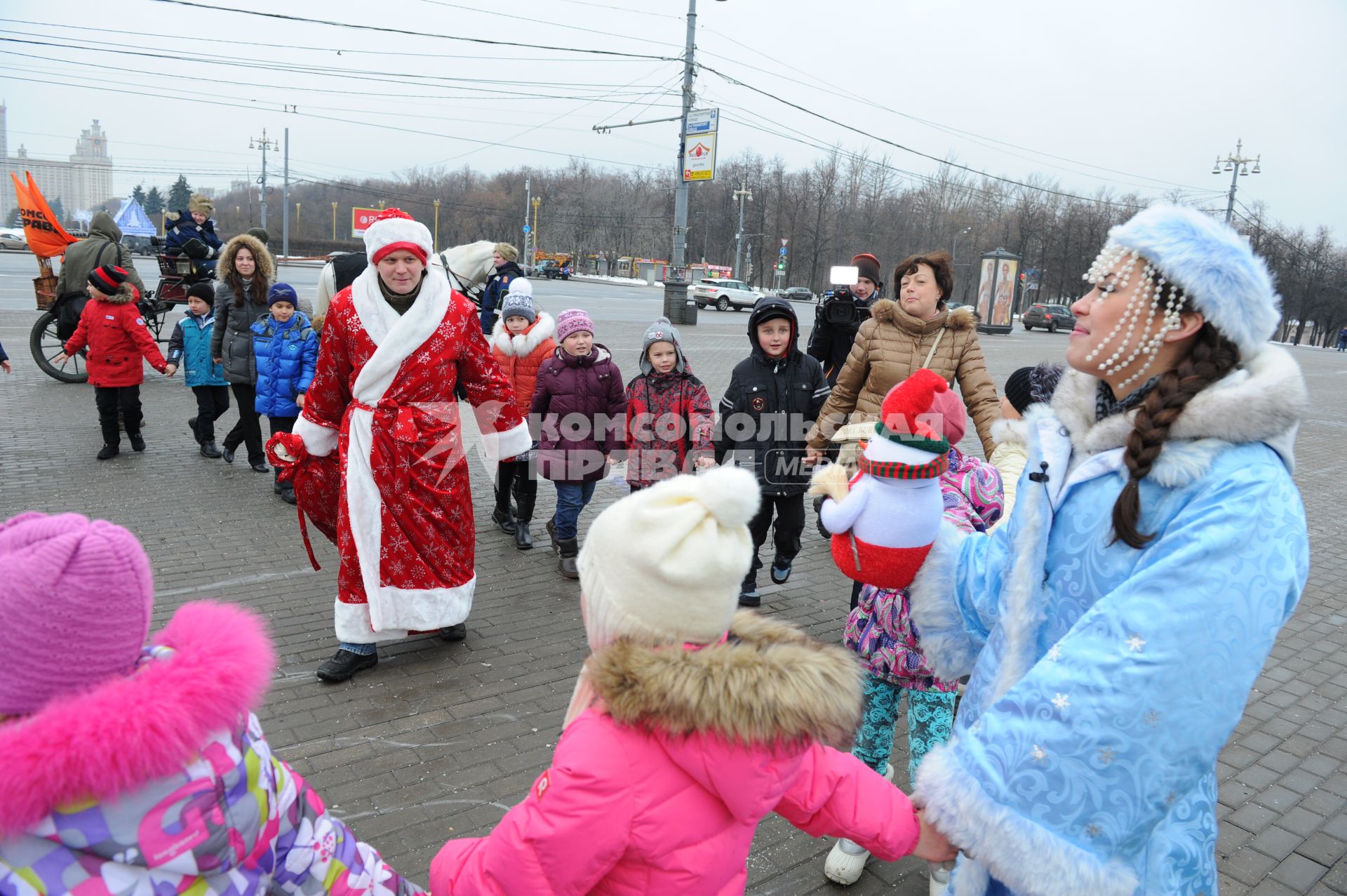 Новогодняя акция КП на смотровой площадке Воробьевых гор. На снимке: корреспондент КП Олег Адамович и телеведущая КП Арина Горшкова раздают подарки детям и водят хоровод.