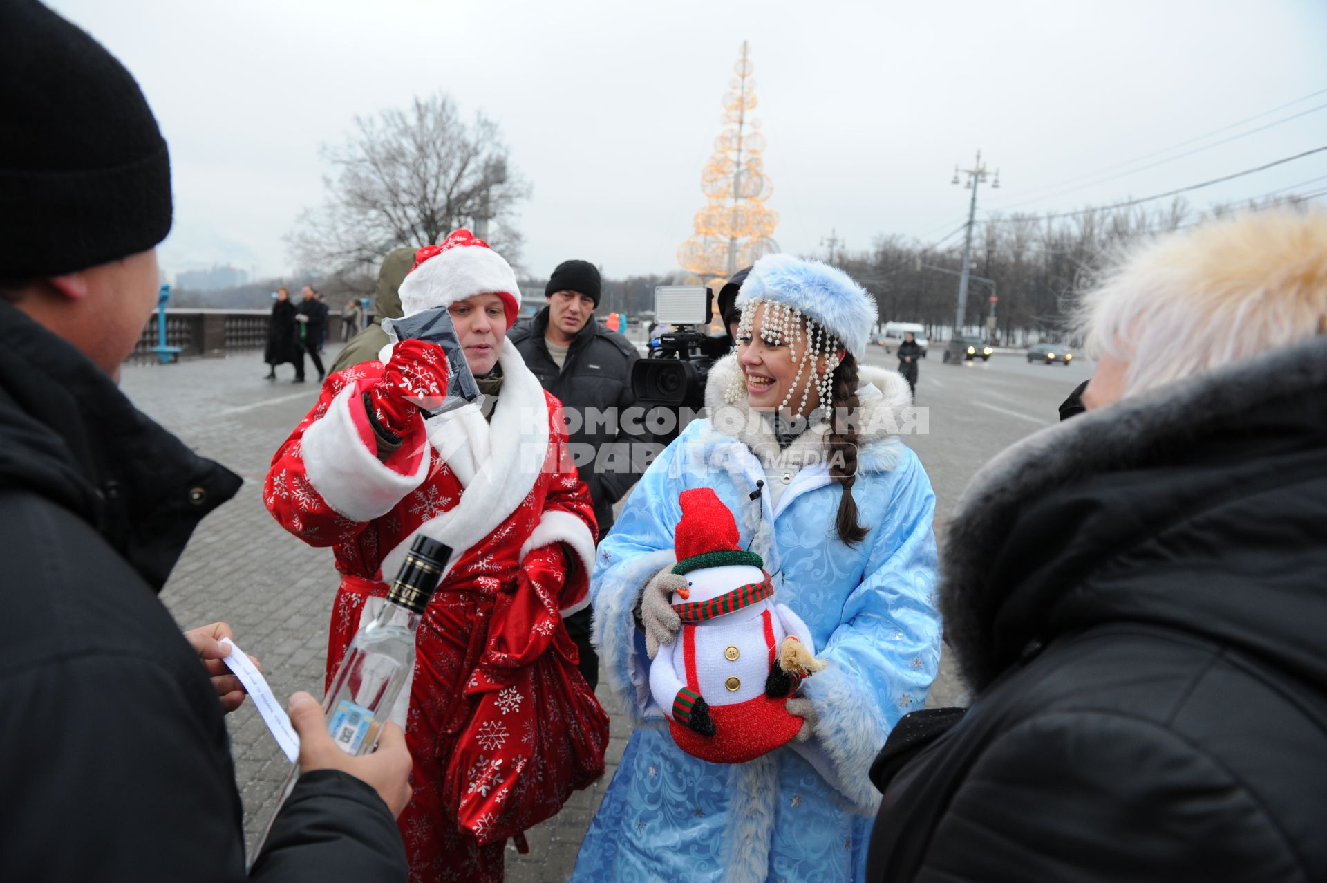 Новогодняя акция КП на смотровой площадке Воробьевых гор. На снимке: корреспондент КП Олег Адамович и телеведущая КП Арина Горшкова раздают подарки людям.