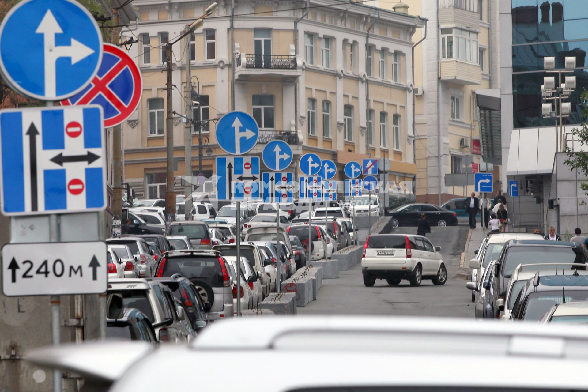 Большое скопление автомобильных дорожных знаков на улице.