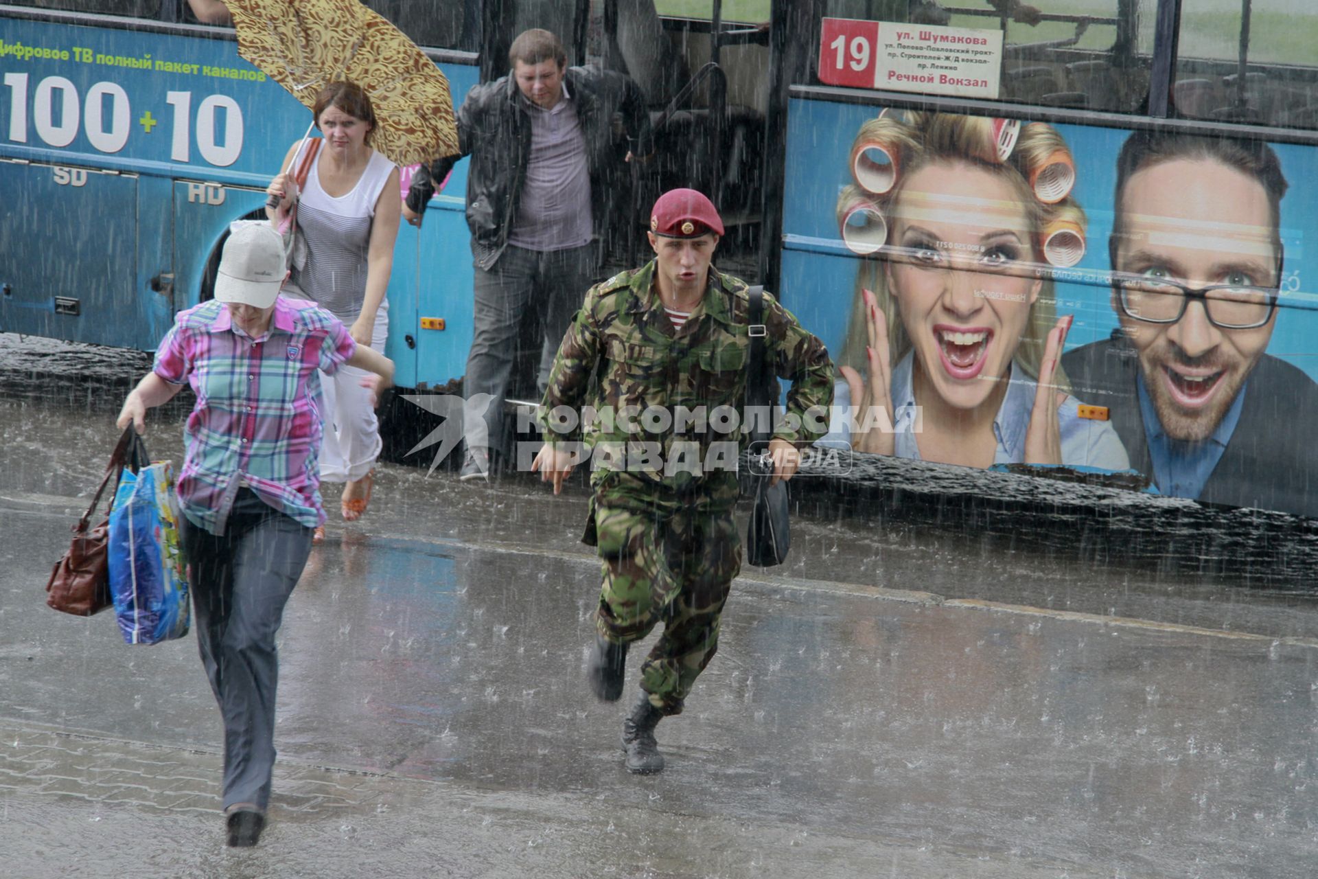Военнослужащий бежит под дождем.