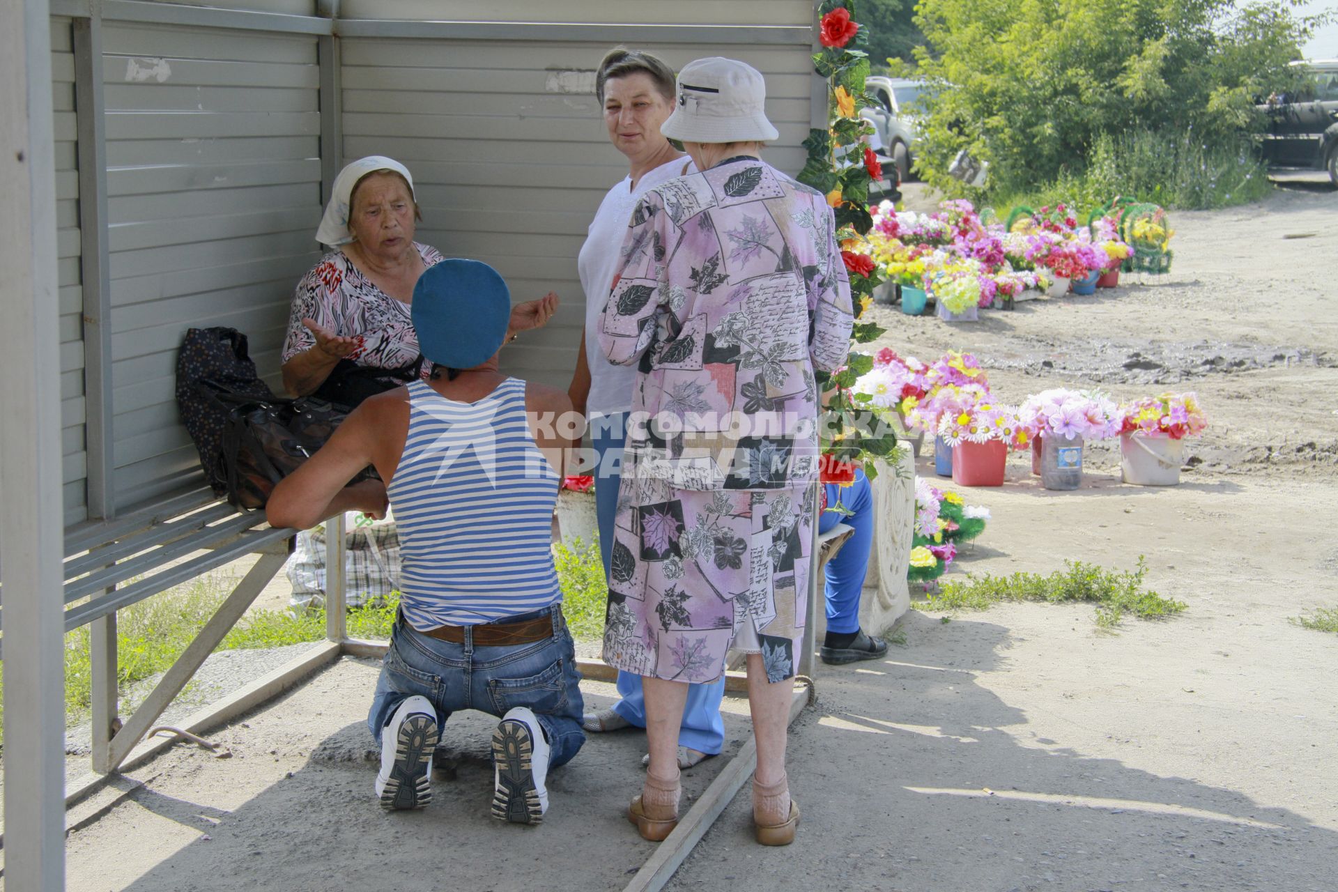 День ВДВ. Десантник стоит на коленях перед бабушкой на остановке у кладбища.