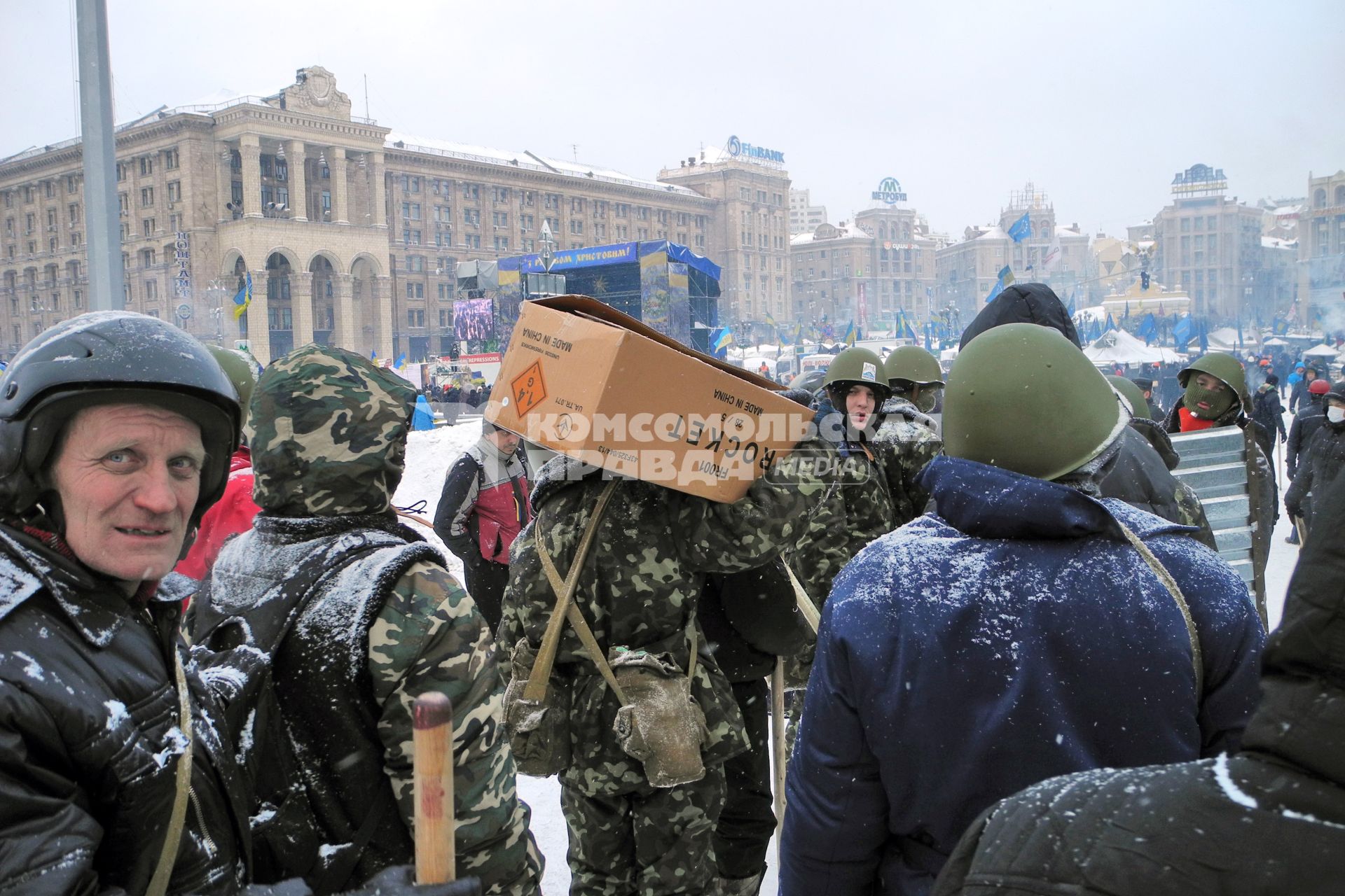 Протестующие несут коробку с пиротехникой.