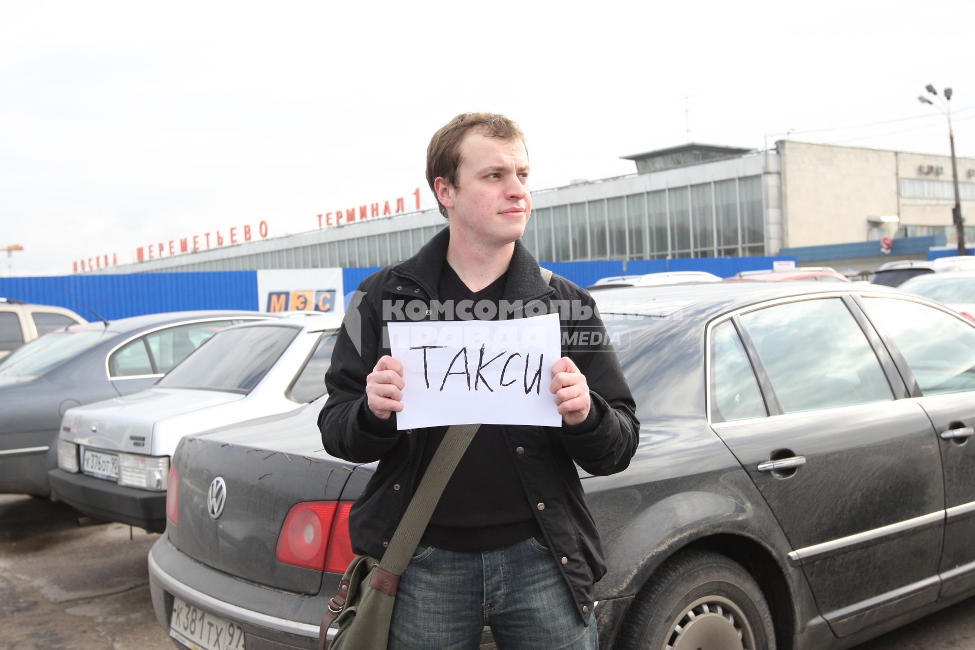 Аэропорт Шереметьево. На снимке: водитель-частник стоит с табличкой `Такси` у Терминала 1.
