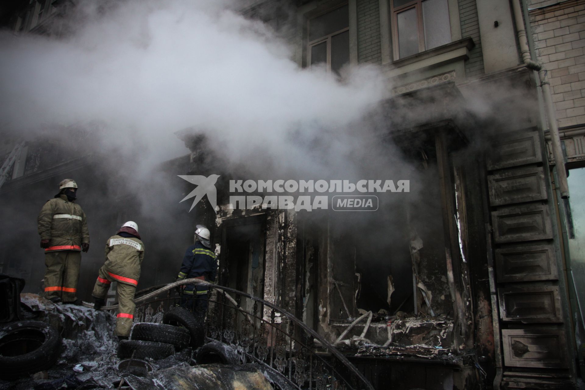 Пожар на улице Грушевского во время протестов в Киеве. На снимке: пожарные за работой.