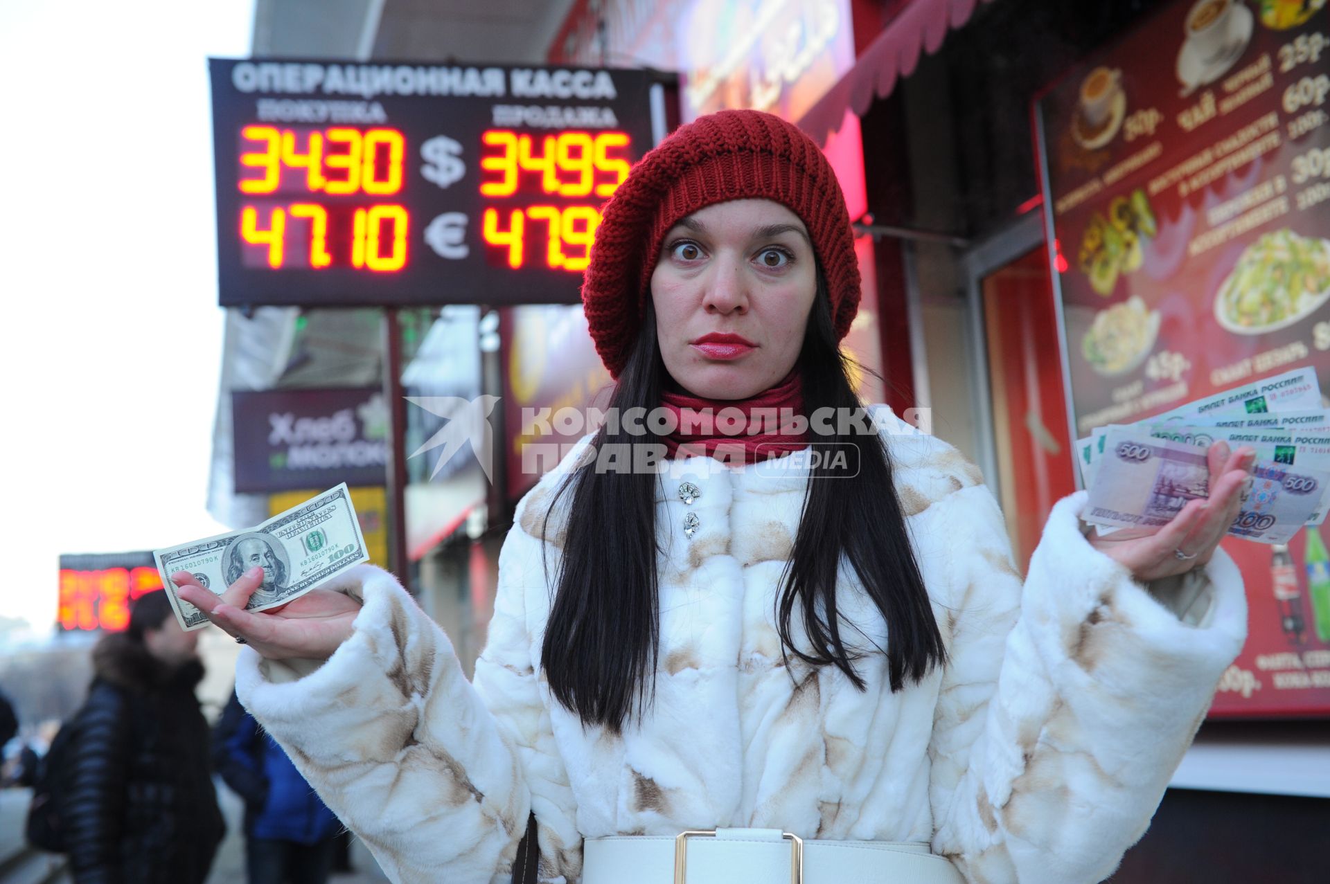 Девушка с деньгами около пункта обмена валюты.