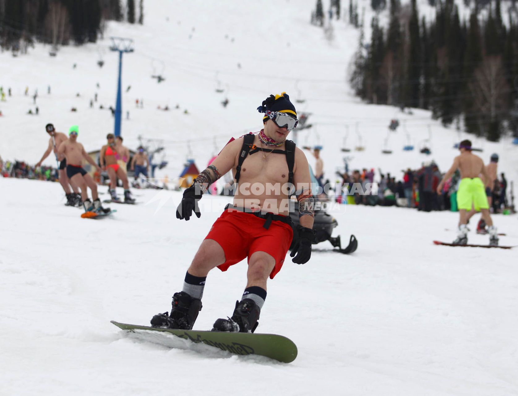 В рамках `Фестиваля весеннего солнцекатания` состоялся спуск полуголых лыжников и сноубордистов. На снимке: мужчина в шортах на сноуборде.