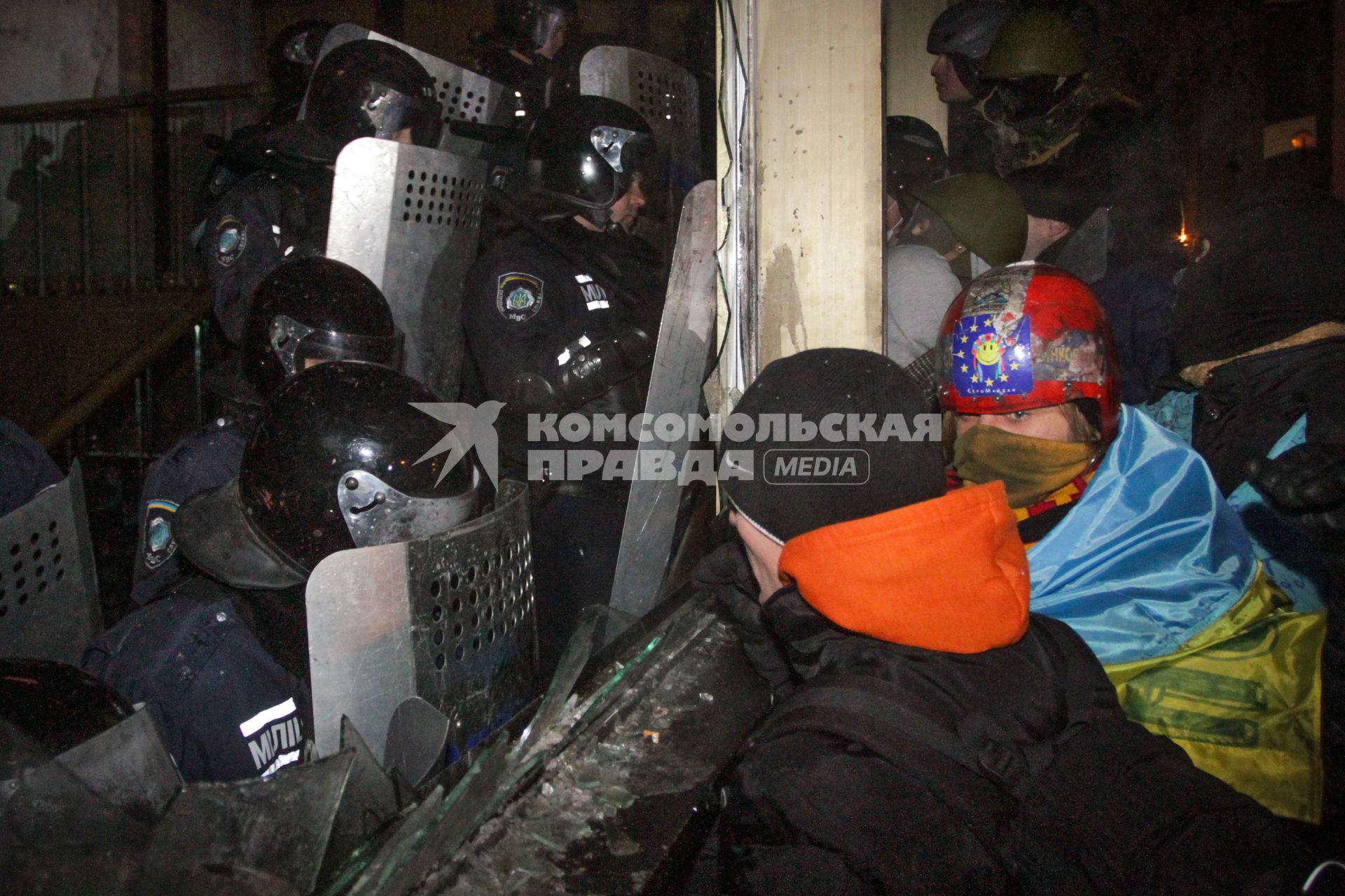 Протестующие штурмуют Украинский дом. На снимке: протестующие у входа в здание ведут переговоры с бойцом специального подразделения `Беркут`.