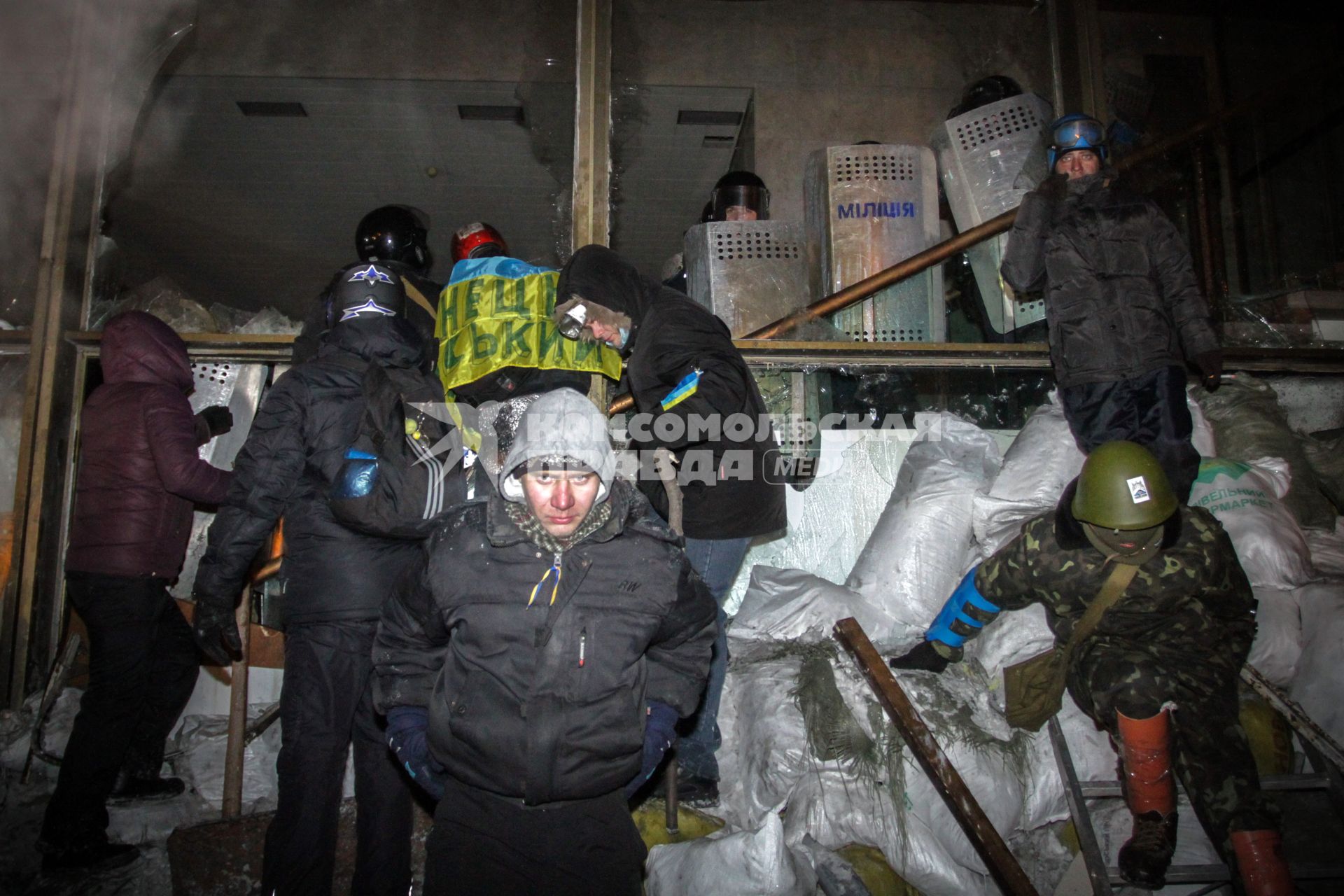 Протестующие штурмуют Украинский дом. На снимке: протестующие и бойцы специального подразделения `Беркут` у входа в здание ведут.