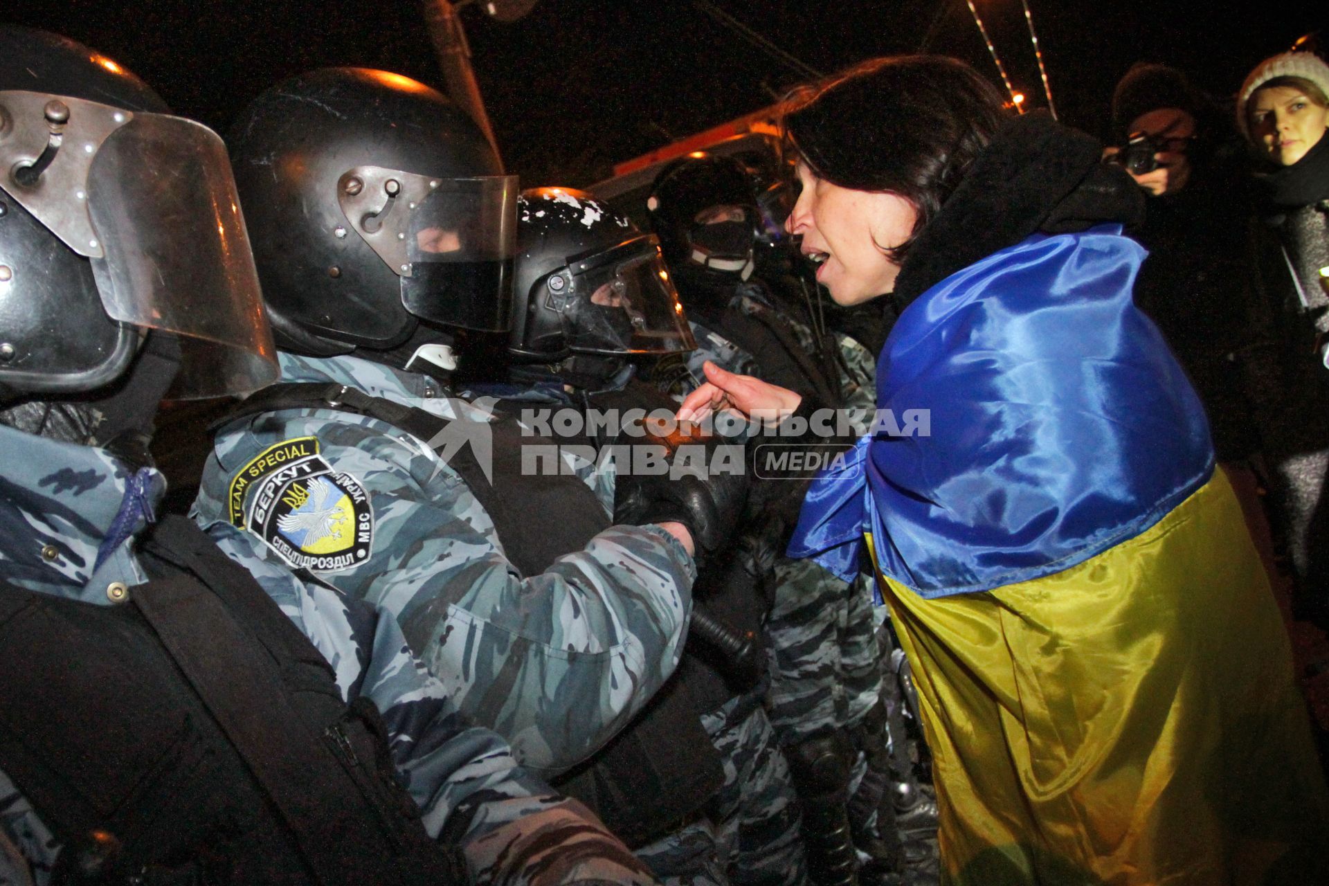 Конфликт между протестующими и бойцами спецподразделения `Беркут`возле Святошинского РОВД. На снимке: протестующая с украинским флагом разговаривает с бойцом `Беркута`.
