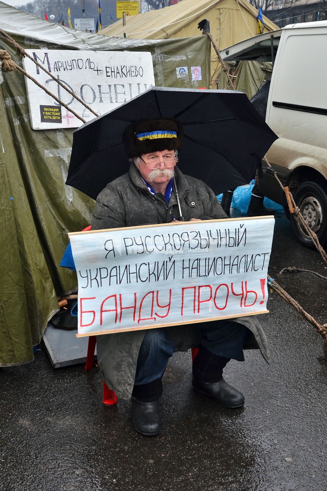 Протестующий с плакатом: `Я русскоязычный украинский националист банду прочь!`