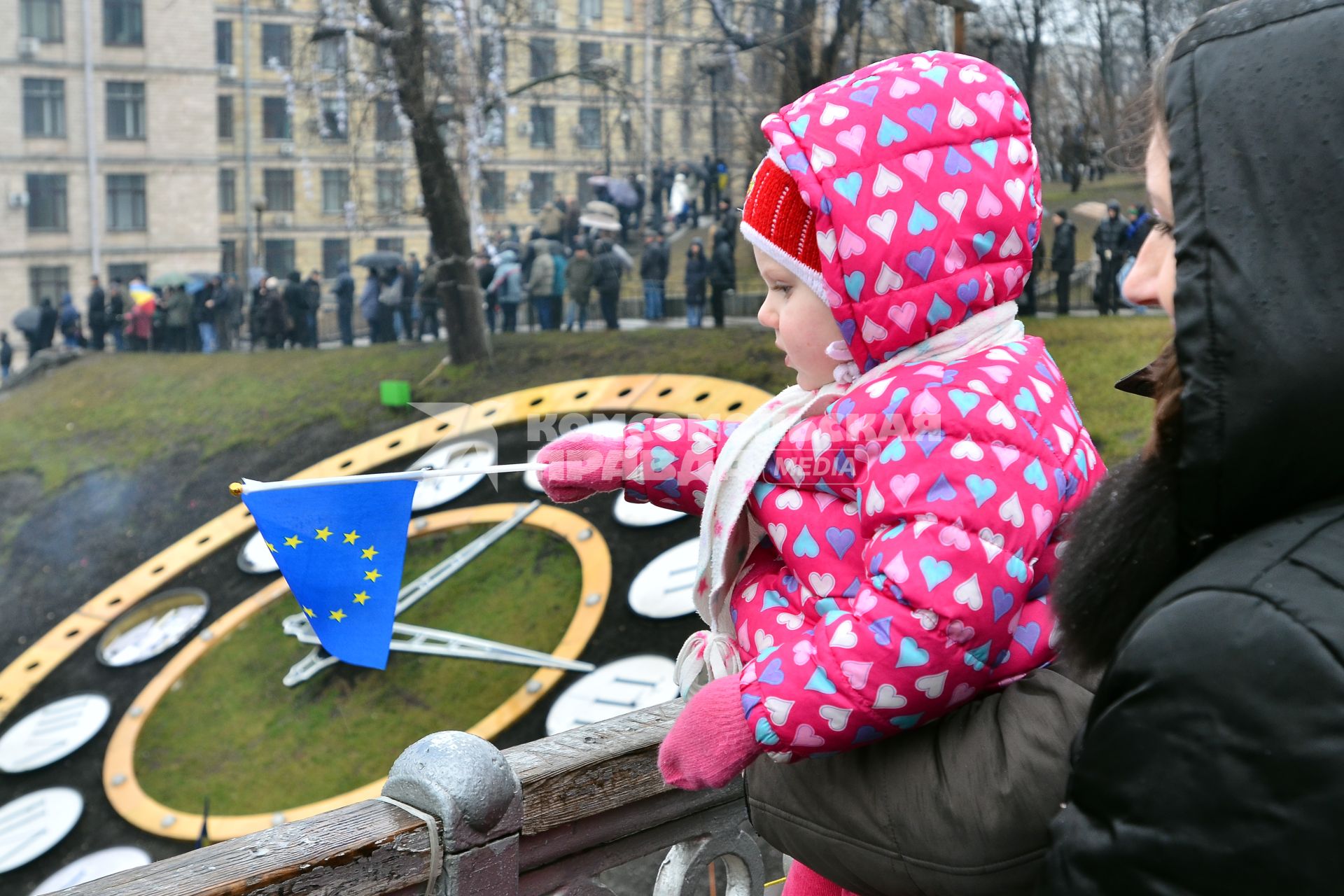 Женщина держит ребенка который держит флг Евросоюза на площади Независимости в Киеве.