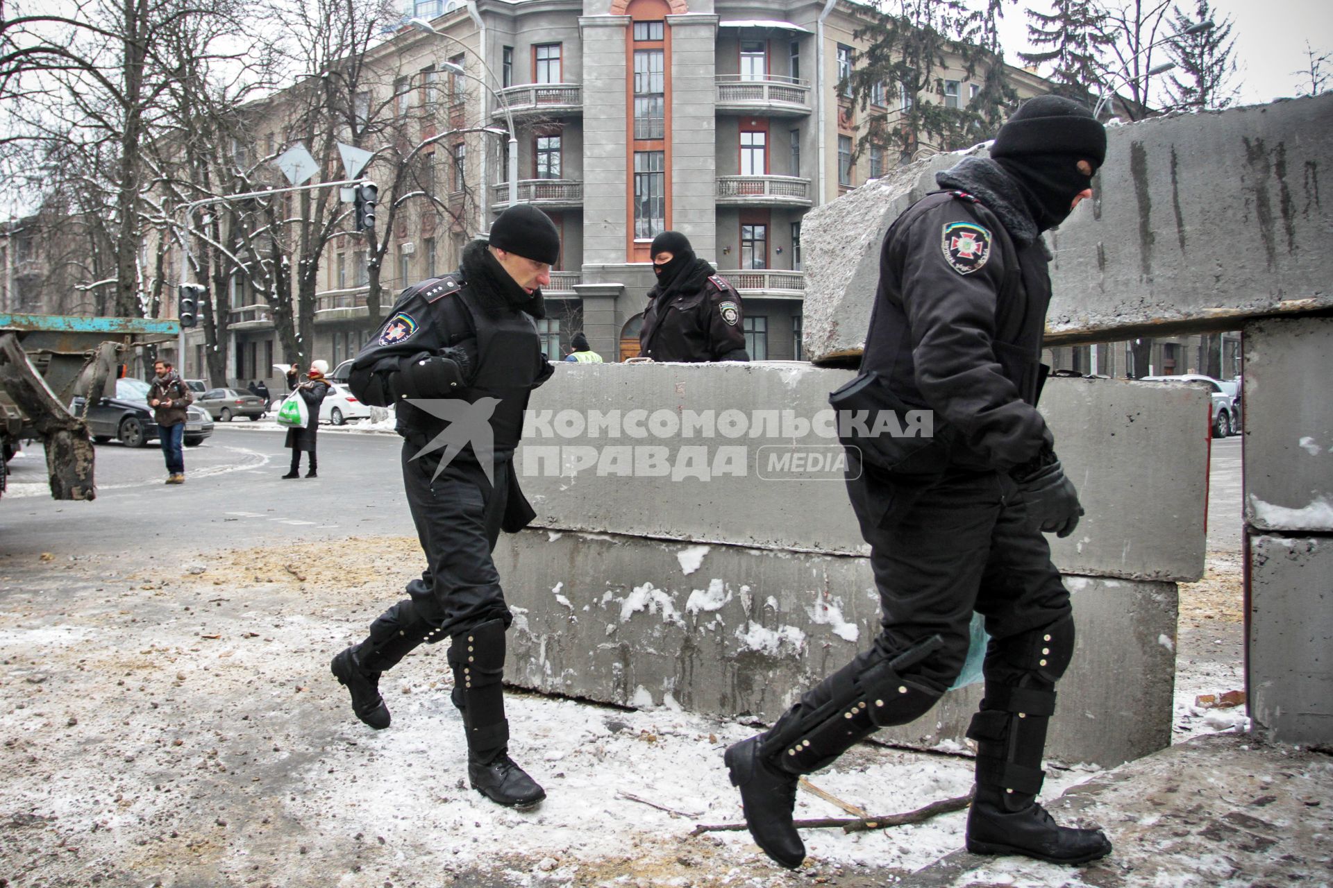 Разбор баррикад на Институтской улице в Киеве. Мимо бетонных блоков проходят сотрудники внутренний войск.