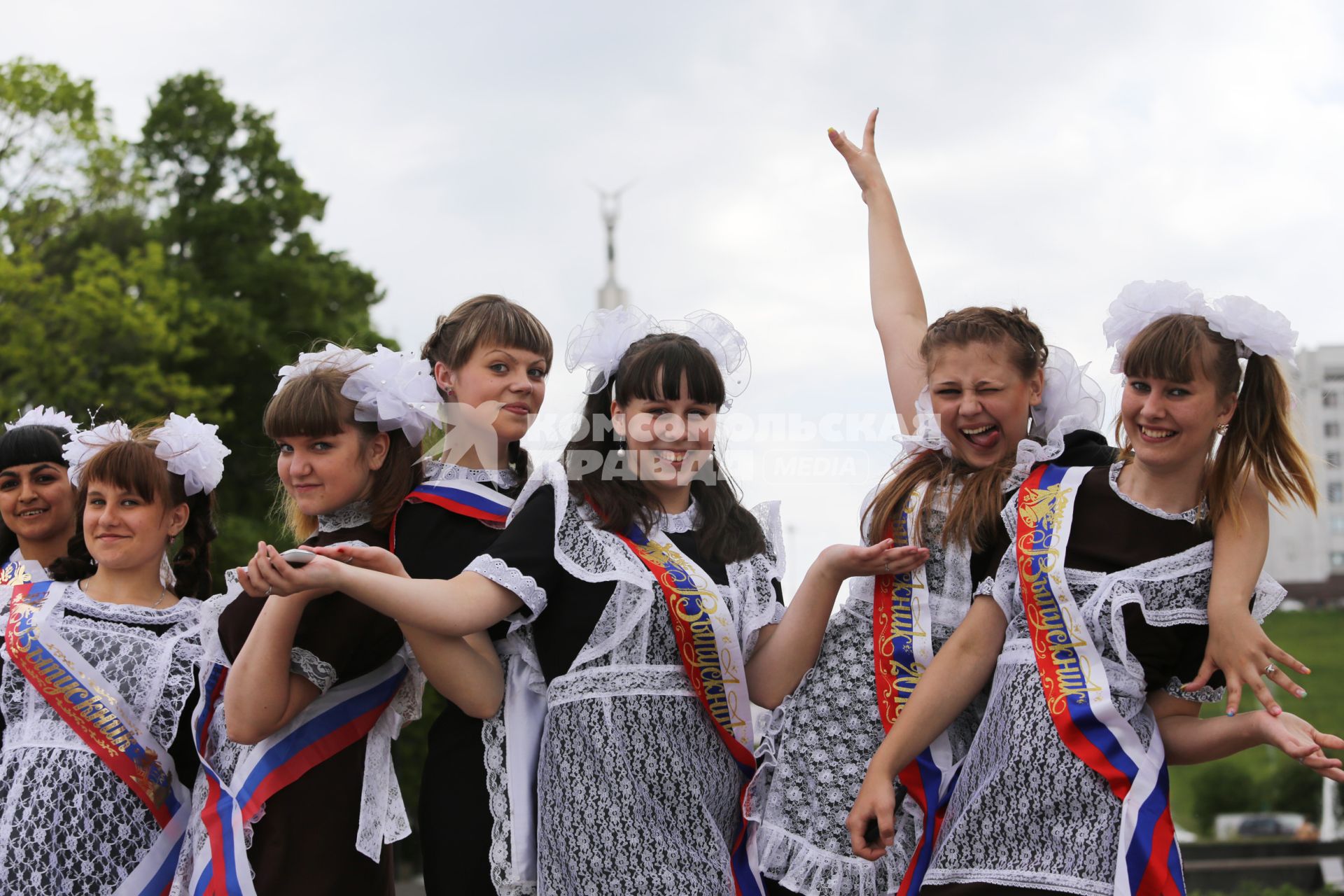 Школьники празднуют последний звонок. На снимке: девушки в парадной школьной форме с лентами выпускниц.