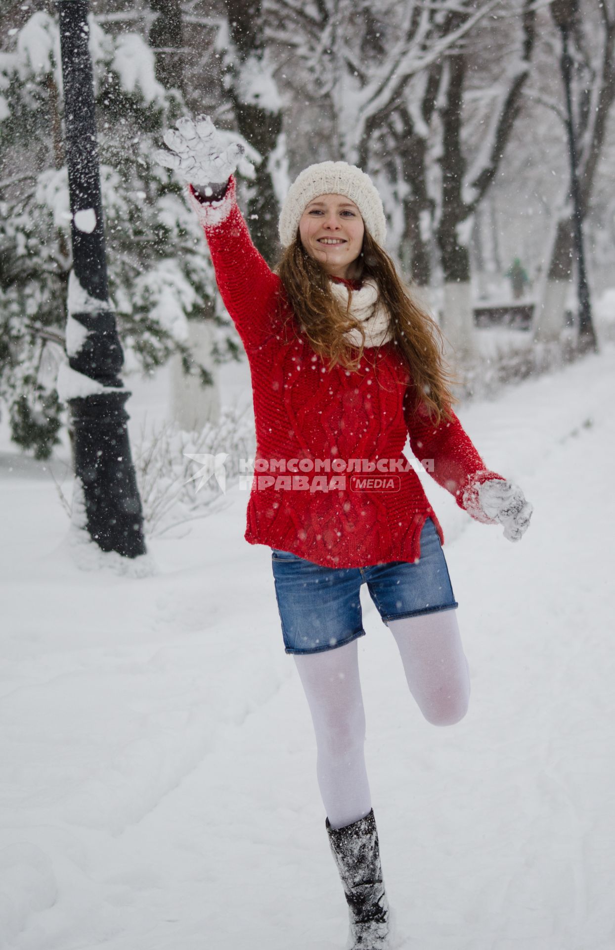 Девушка играет в снежки.