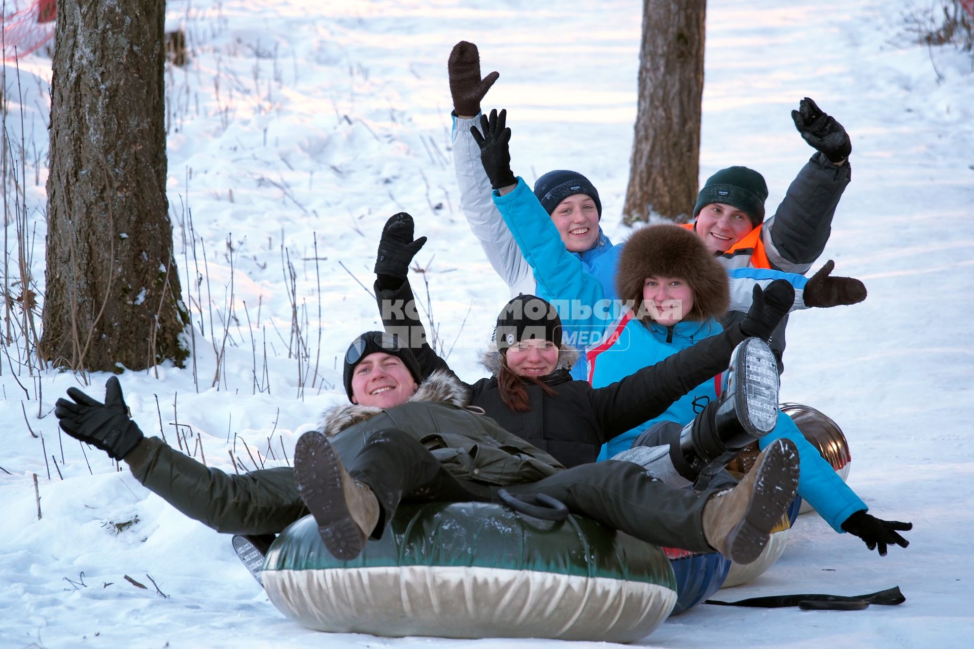 Компания молодых людей на тюбинге.