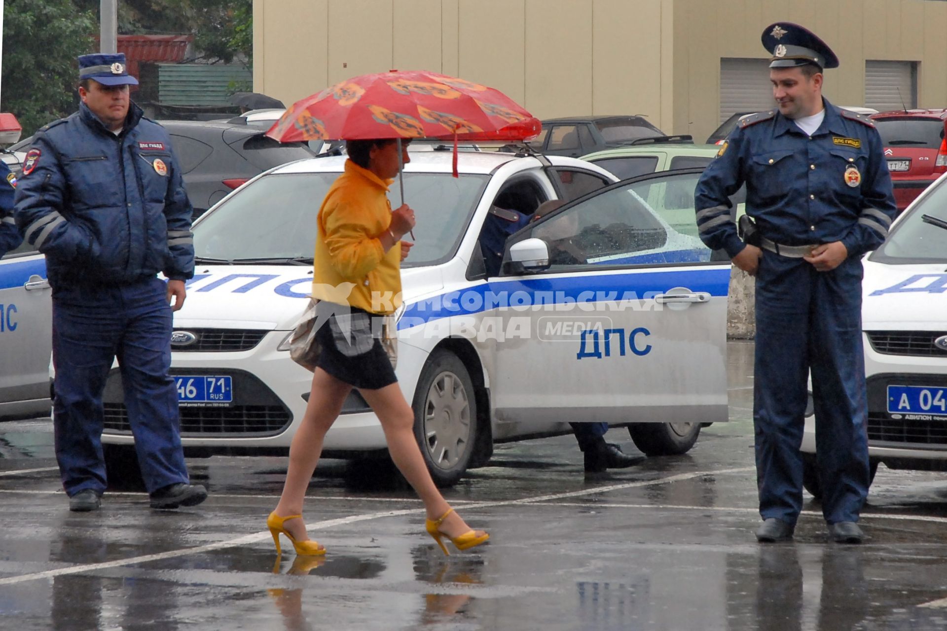 Девушка в короткой юбке идет под дождем, на нее засмотрелись два сотрудника ДПС.