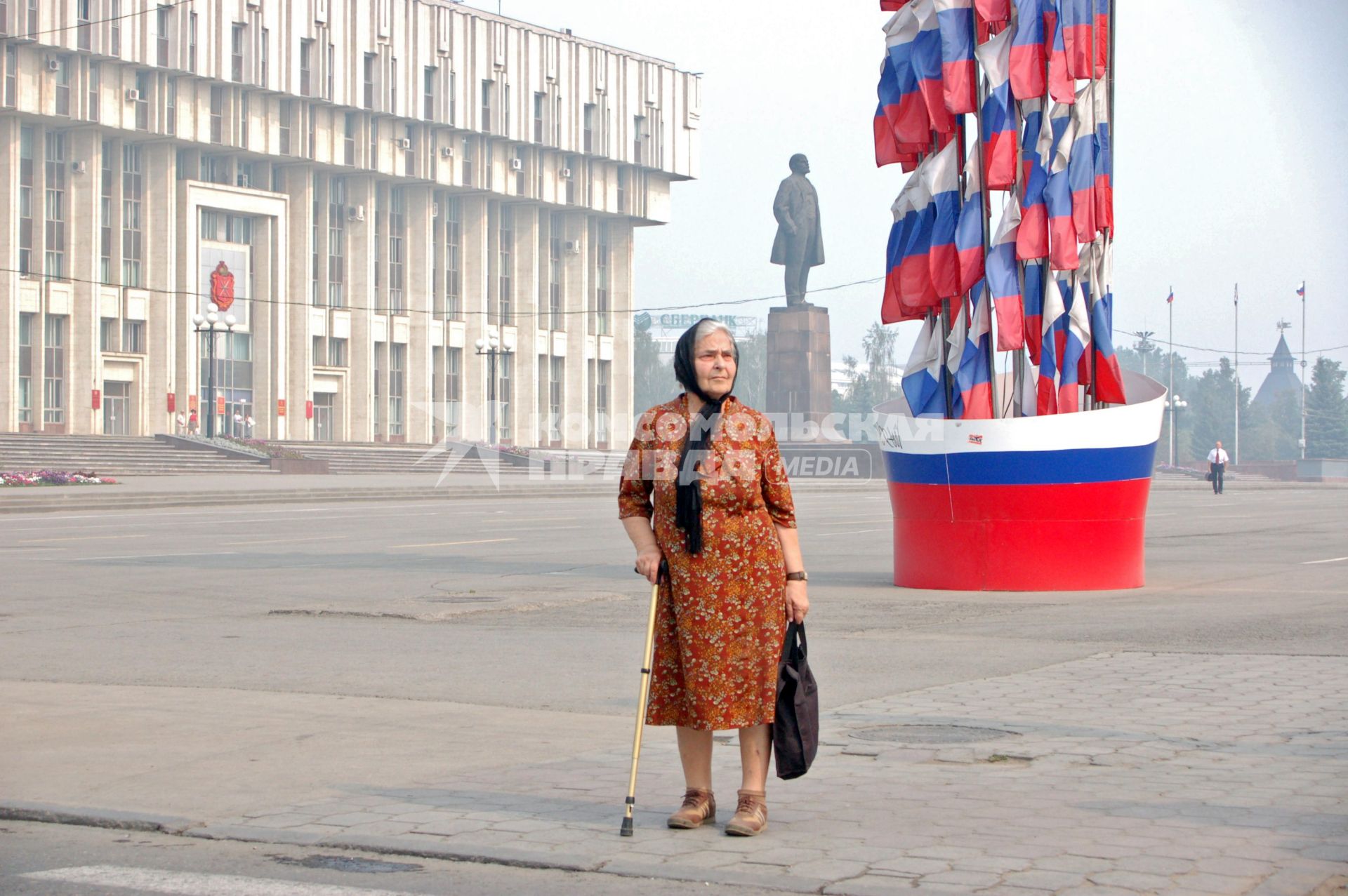 Пенсионерка на фоне памятника Ленину и здания администрации Тулы.