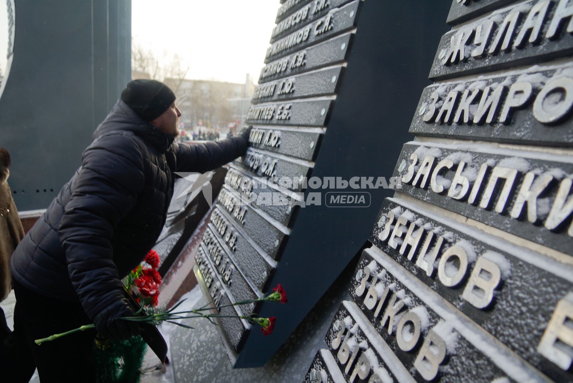 День вывода войск из Афганистана. Мужчина у памятника `Черный тюльпан` в честь погибших в ходе Афганской войны дополненный гранитными стелами с фамилиями военнослужащих, погибших в Чеченской Республике и Дагестане.