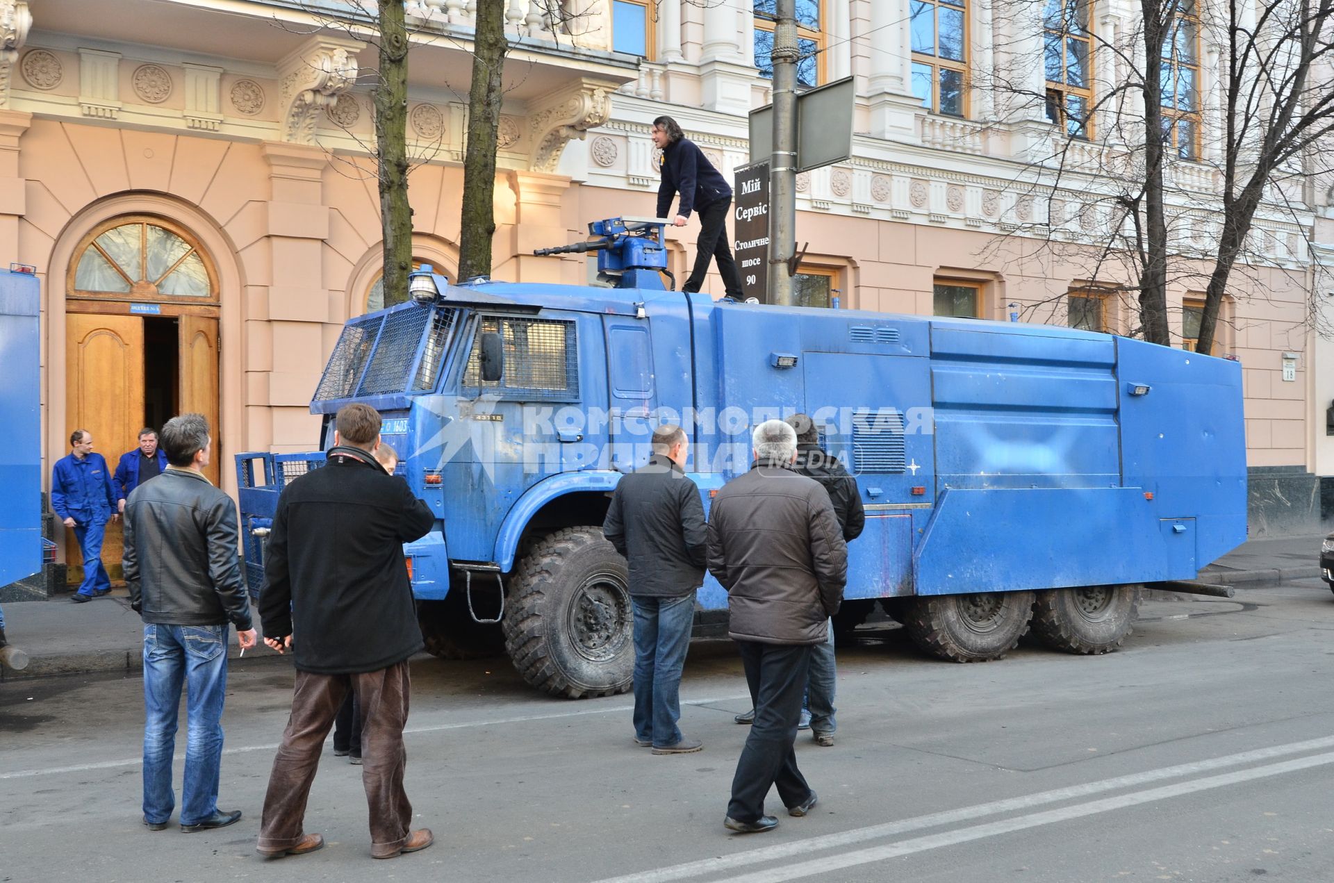 Прохожий забрался на бронированный водомет.