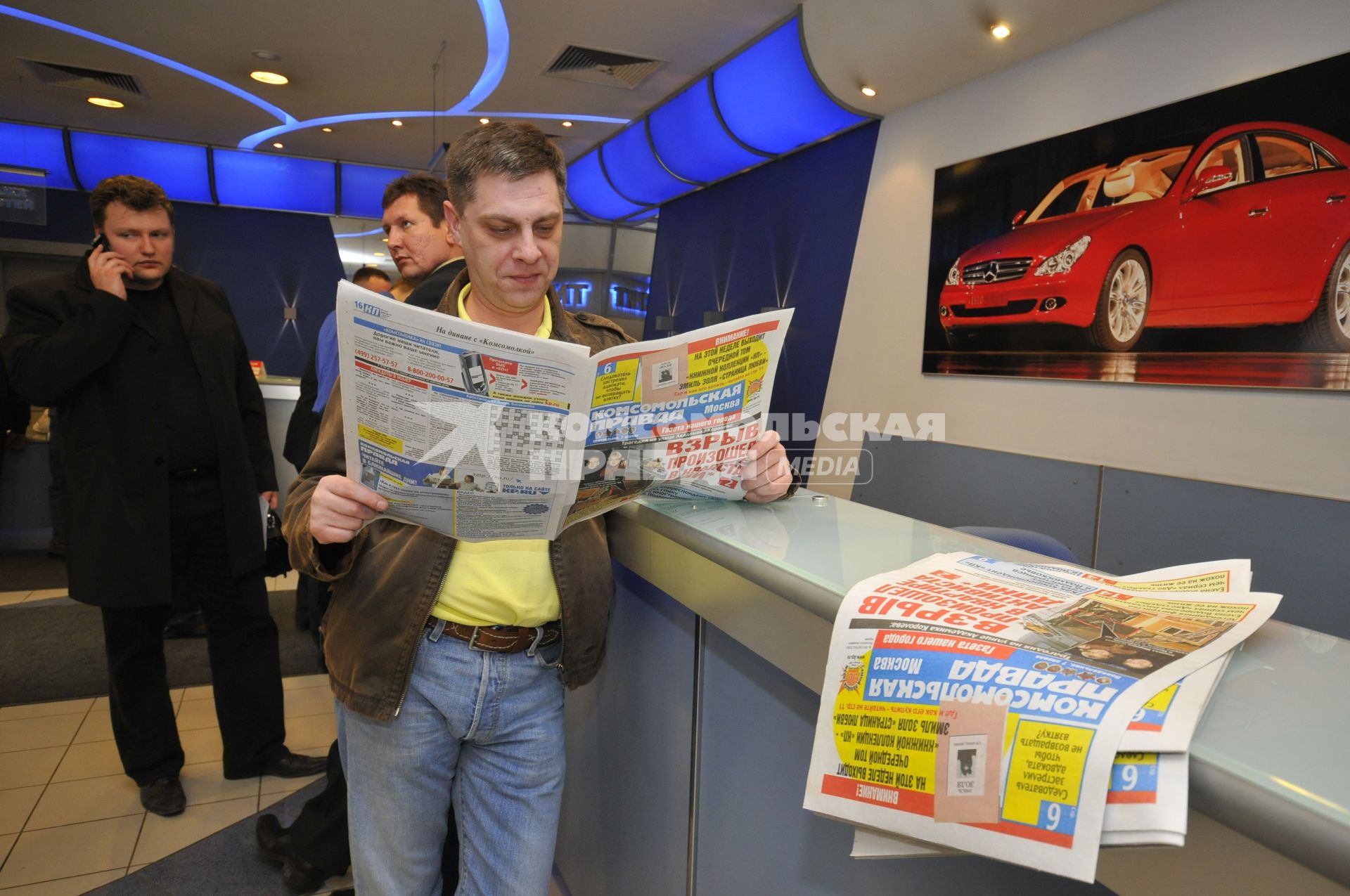 Мужчина читает газету `Комсомольская правда`.