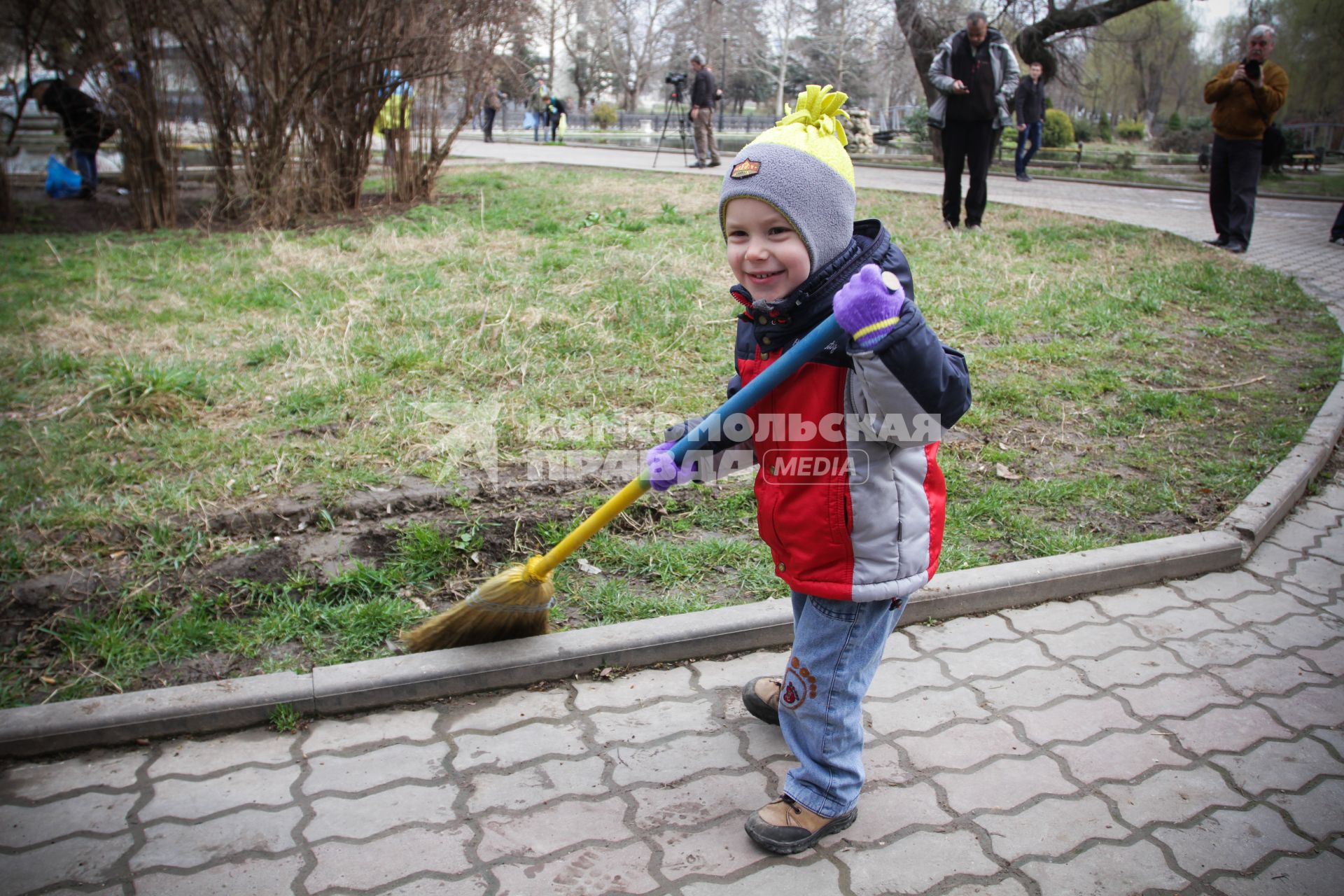 Ребенок с метлой сине-желтого цвета.