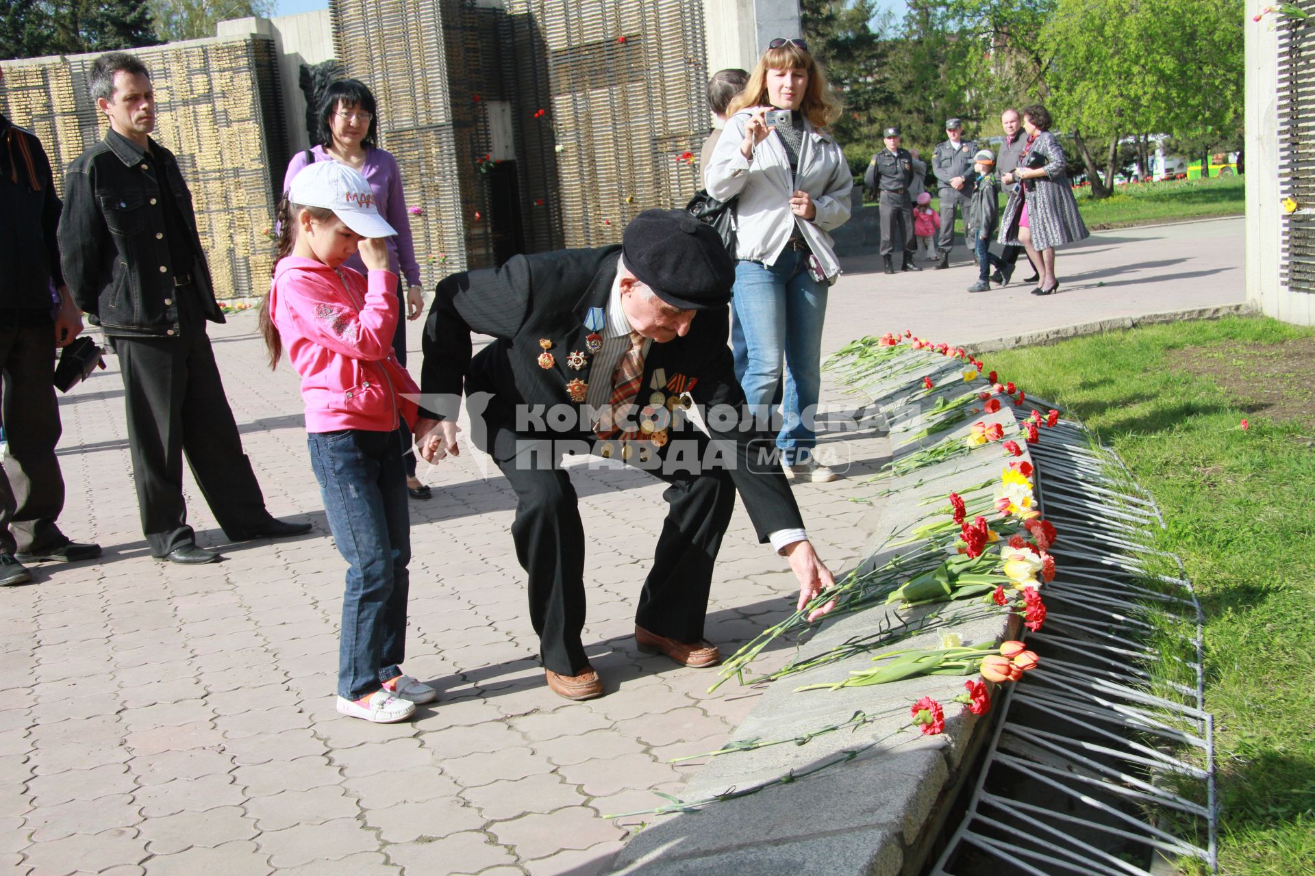 Ветеран возлагает цветы к мемориалу.