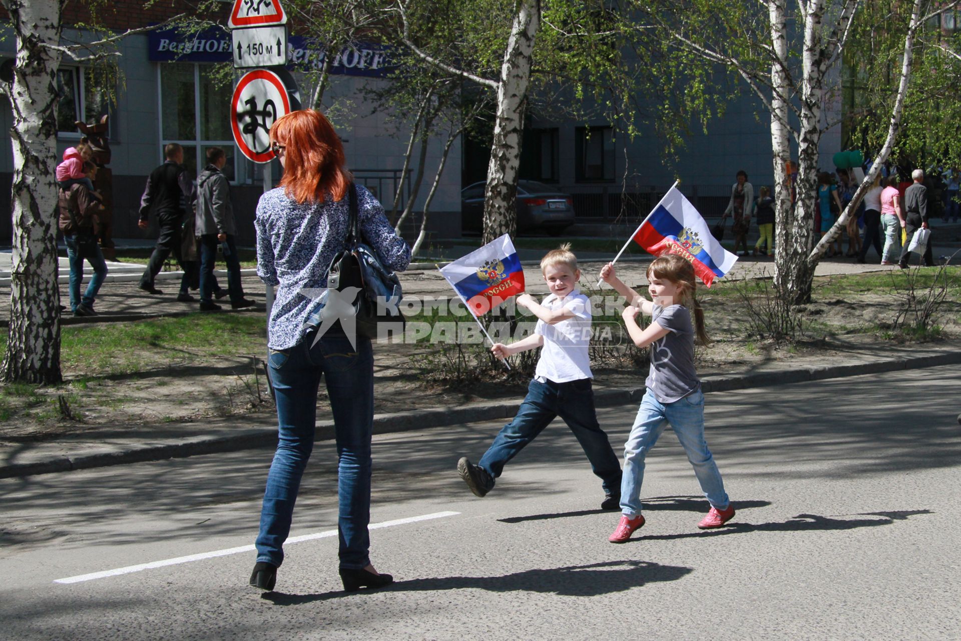 Дети с российскими флагами на улице во время празднования Дня Победы.