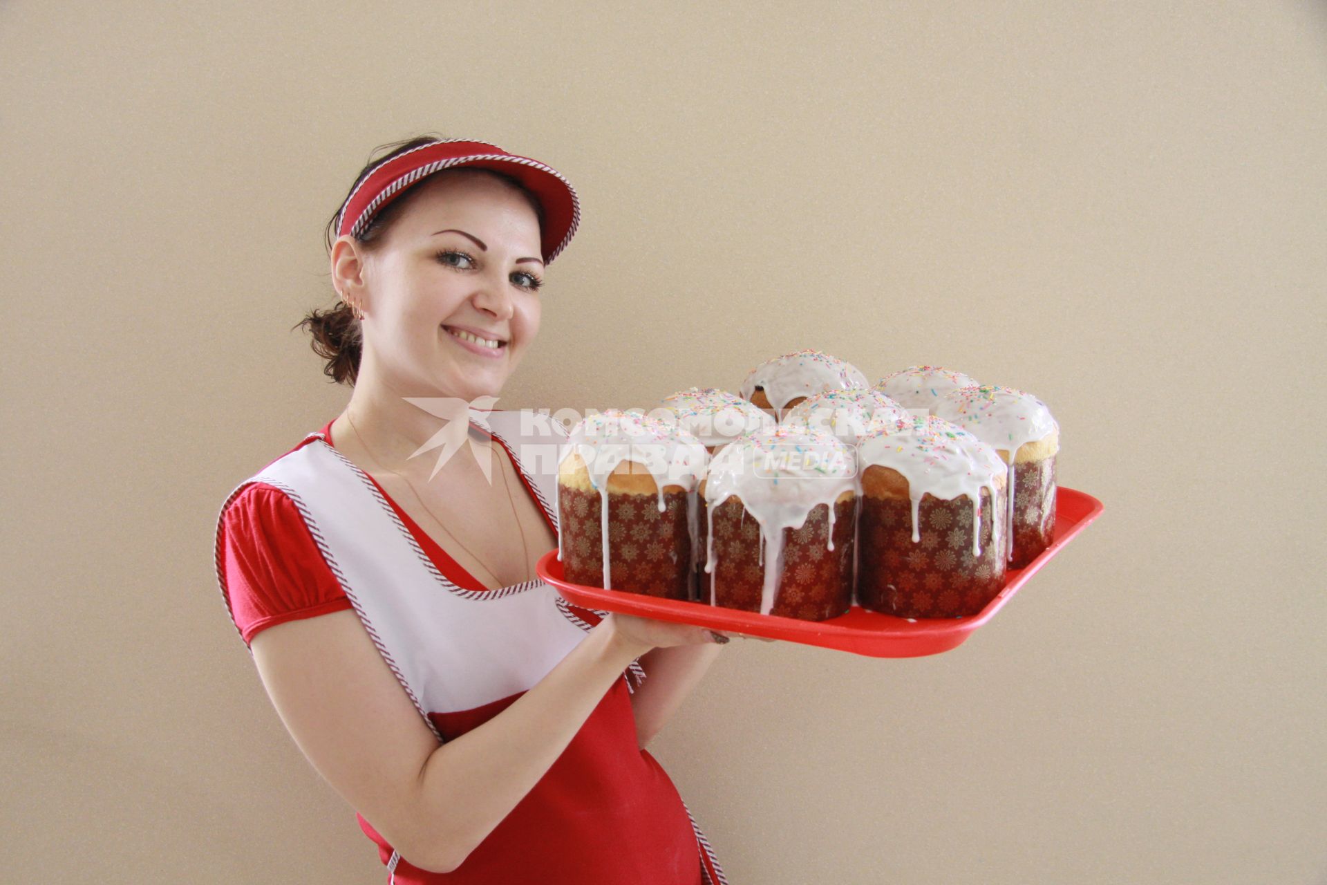 Девушка с пасхальными куличами в пекарне.