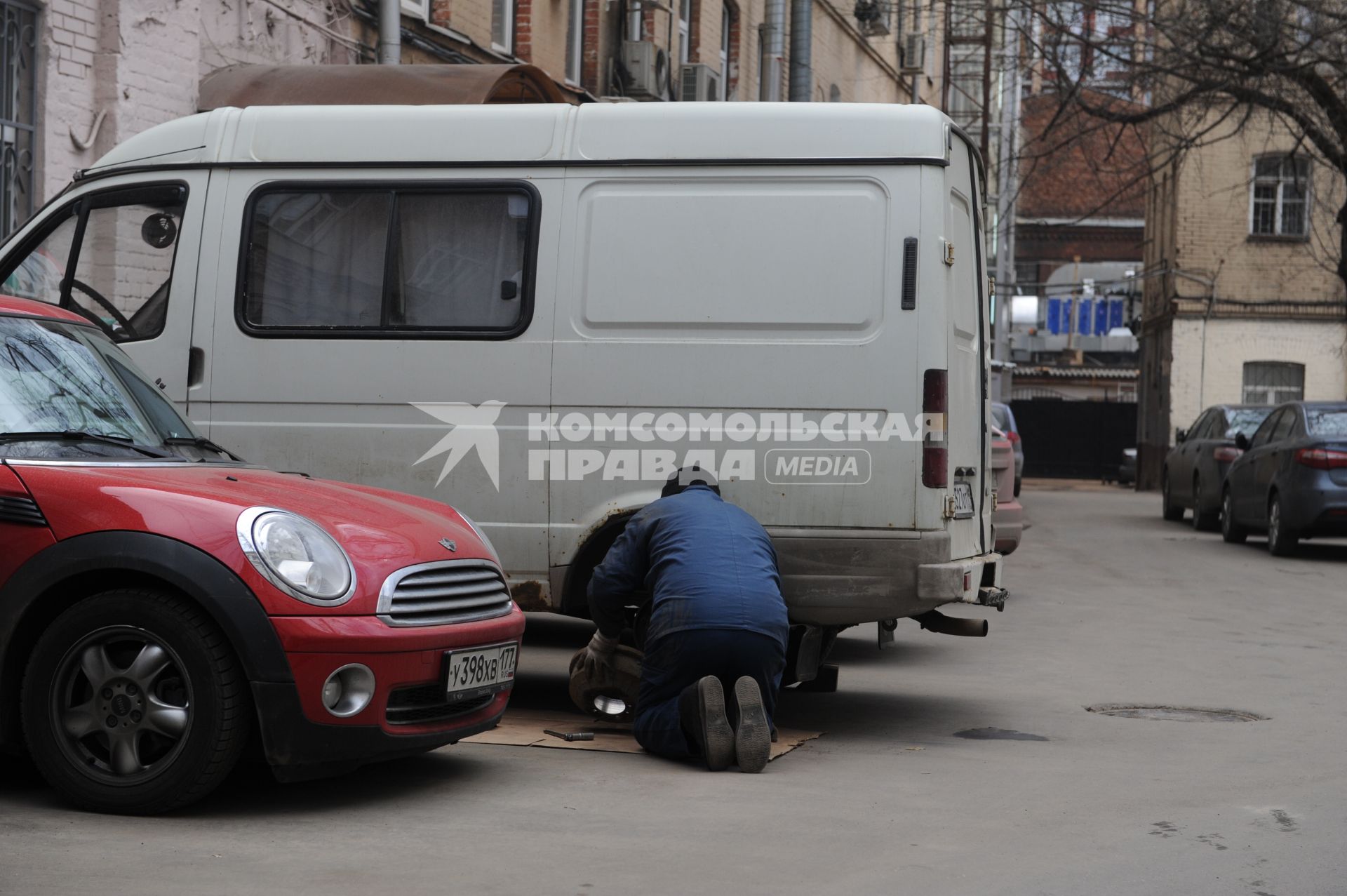 Мужчина ремонтирует колесо автомобиля.