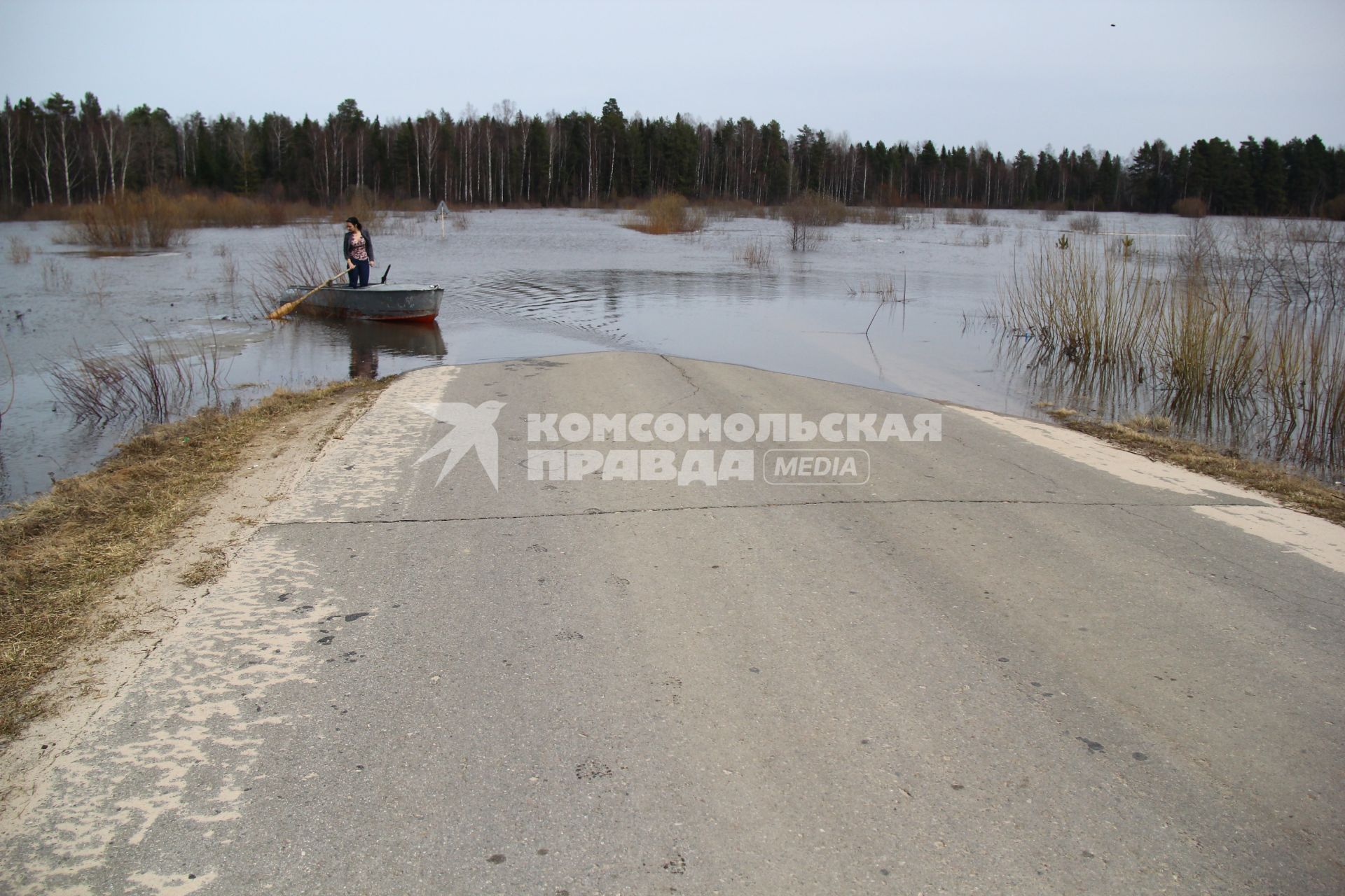 Паводок на реке Уста Уренского района Нижегородской области. Затопленная автомобильная дорога. Девушка в весельной лодке на река во время паводка.