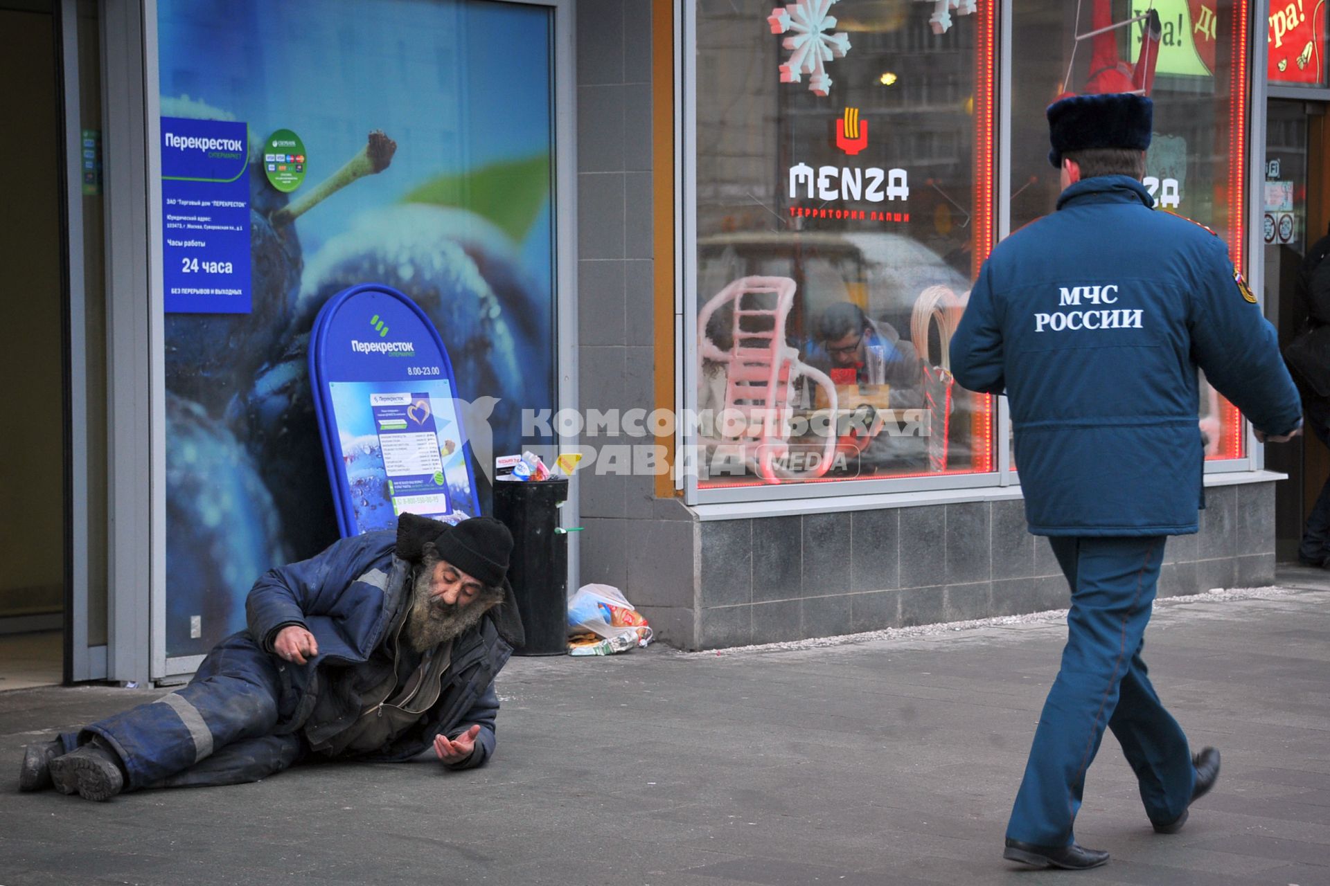 Бомж лежит на улице и просит милостыню.