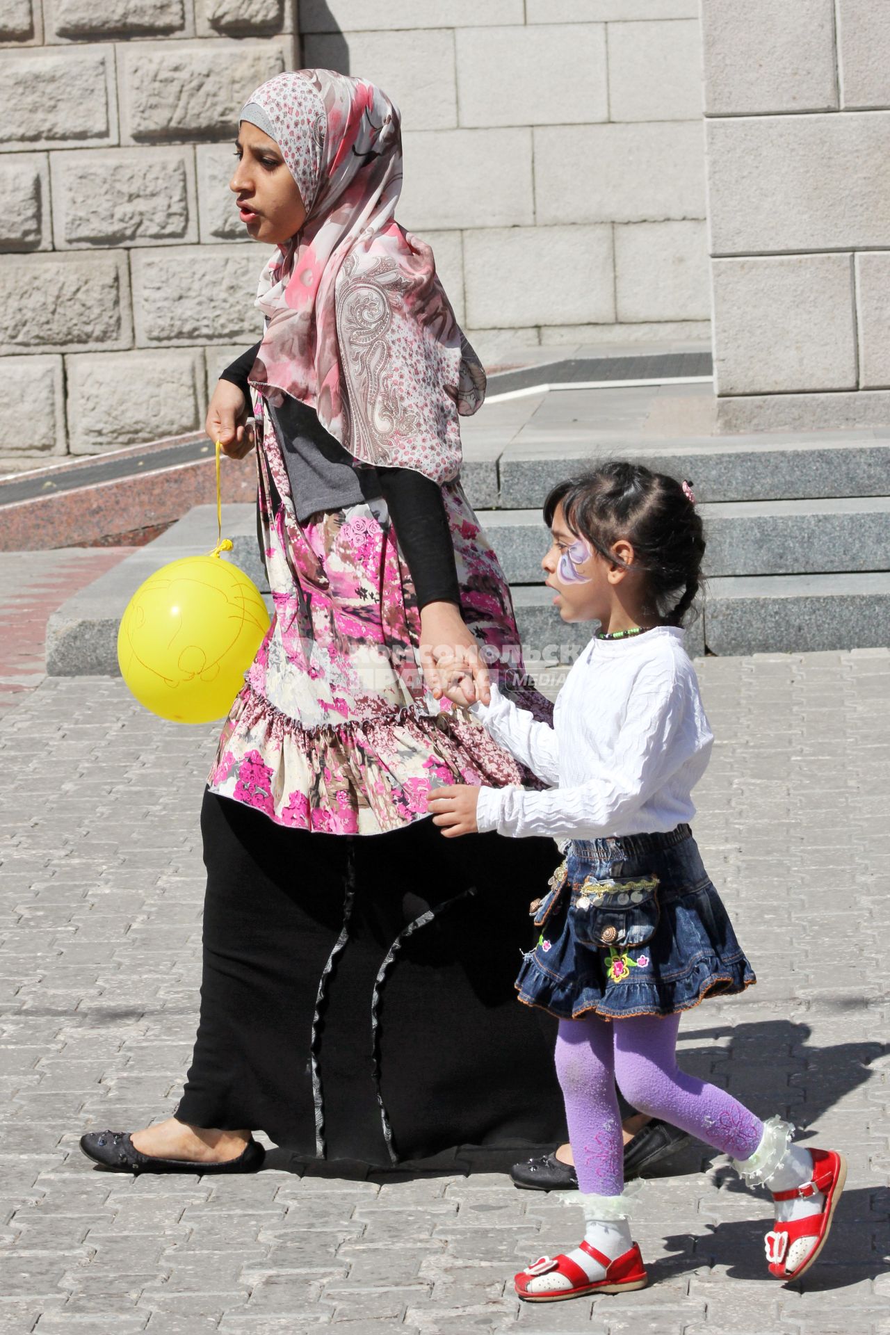 Женщина в хиджабе с ребенком.