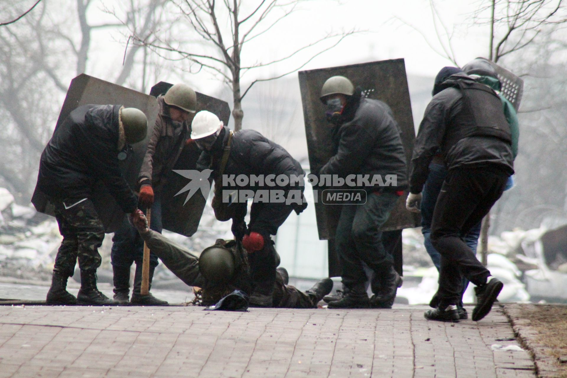 Представители оппозиции волокут раненного протестующего.