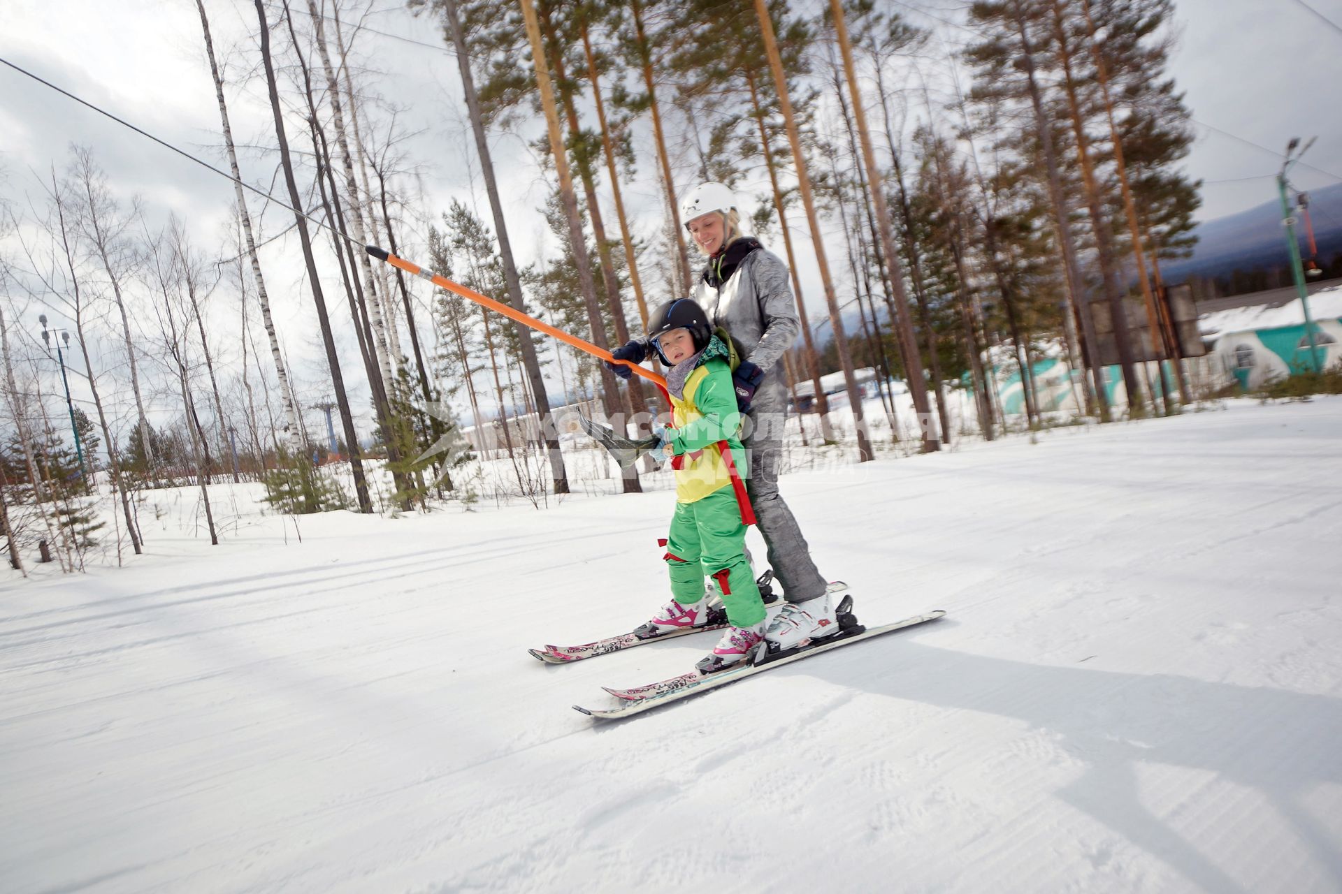 Закрытие горнолыжного сезона на горе Ежовая в Свердловской области. Женщина с ребенком поднимаются на бугельном подъемнике.