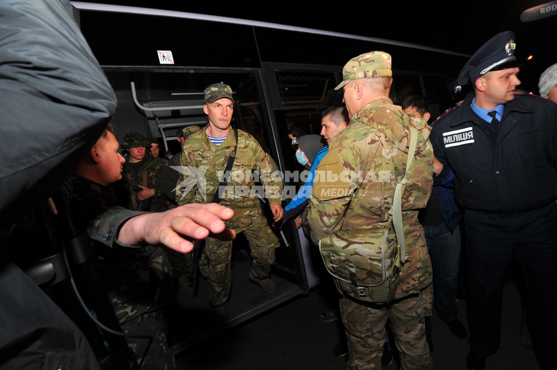 Ситуация в Донецке. У военкомата местные жители перекрыли дорогу автобусу с украинскими номерами, в котором находились военные с оружием без  опознавательных знаков. На снимке: военные выходят из автобуса и направляются в здание военкомата.