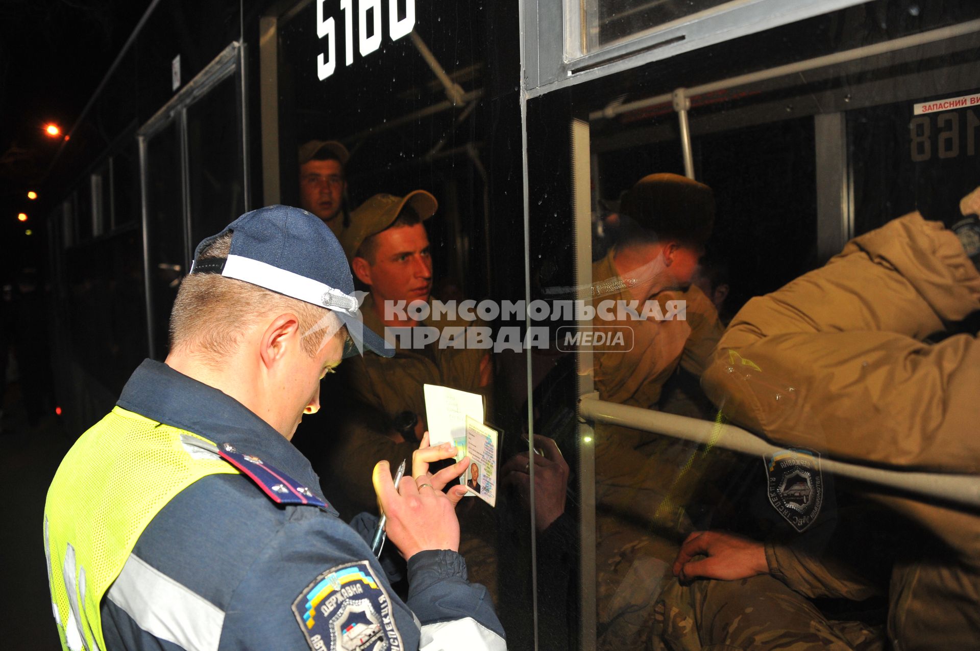 Ситуация в Донецке. У военкомата местные жители перекрыли дорогу автобусу с украинскими номерами, в котором находились военные с оружием без  опознавательных знаков. На снимке: милиционер переписывает данные водителя автобуса.