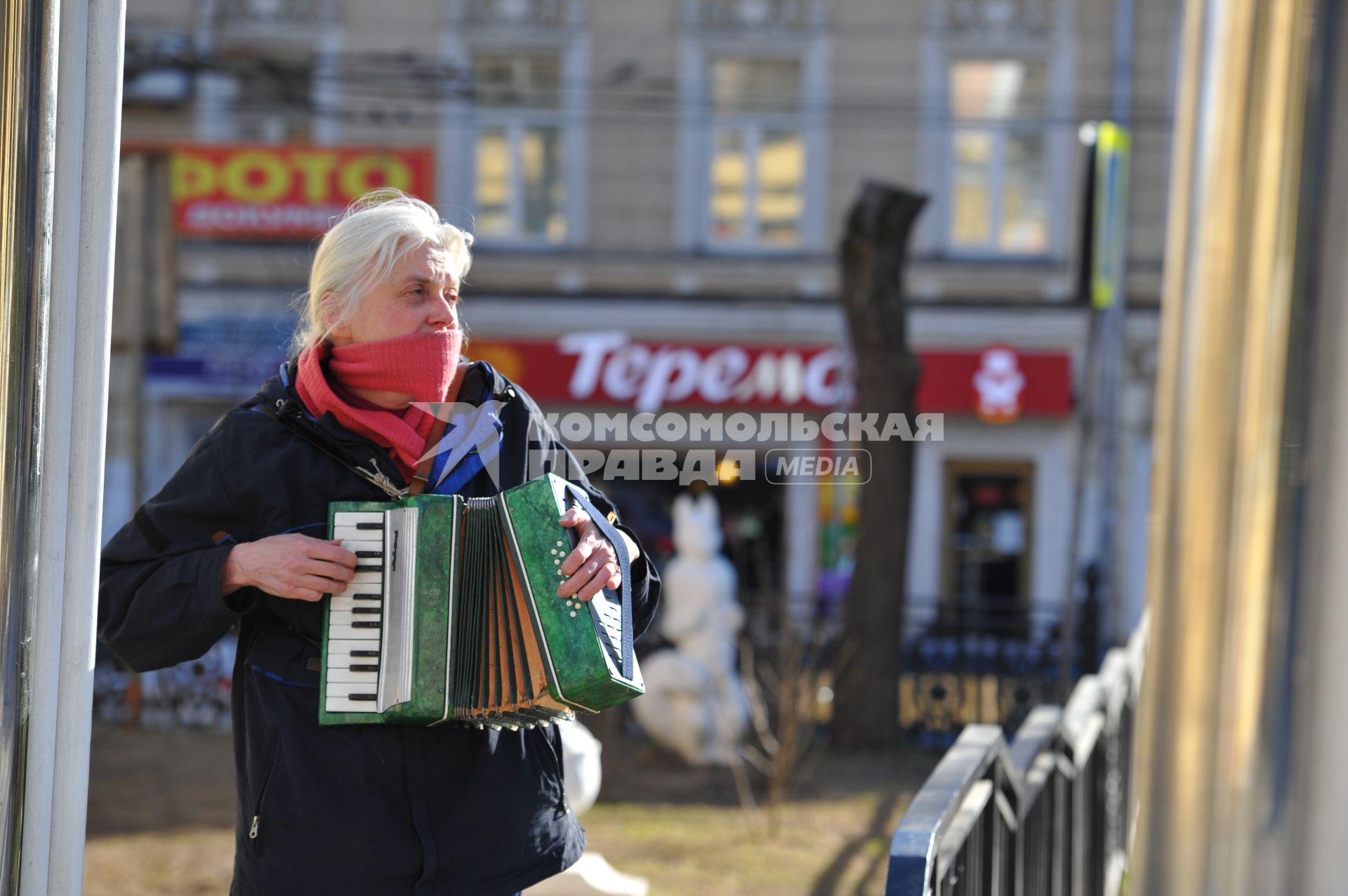 Женщина играет на аккордеоне.