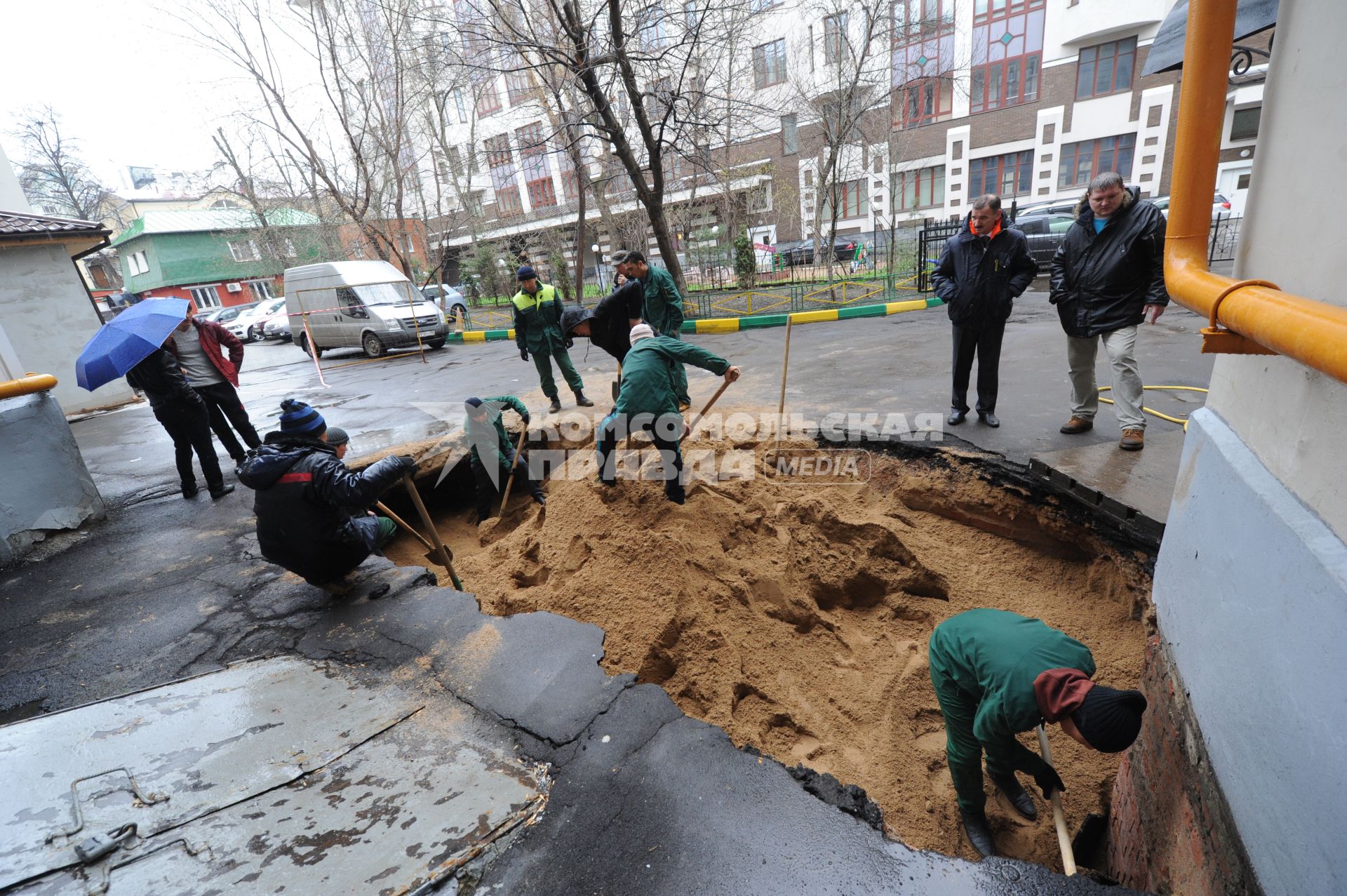 В Филипповском переулке дом # 16 произошел провал грунта. На снимке: рабочие коммунальной службы засыпают песком участок, где провалился грунт.