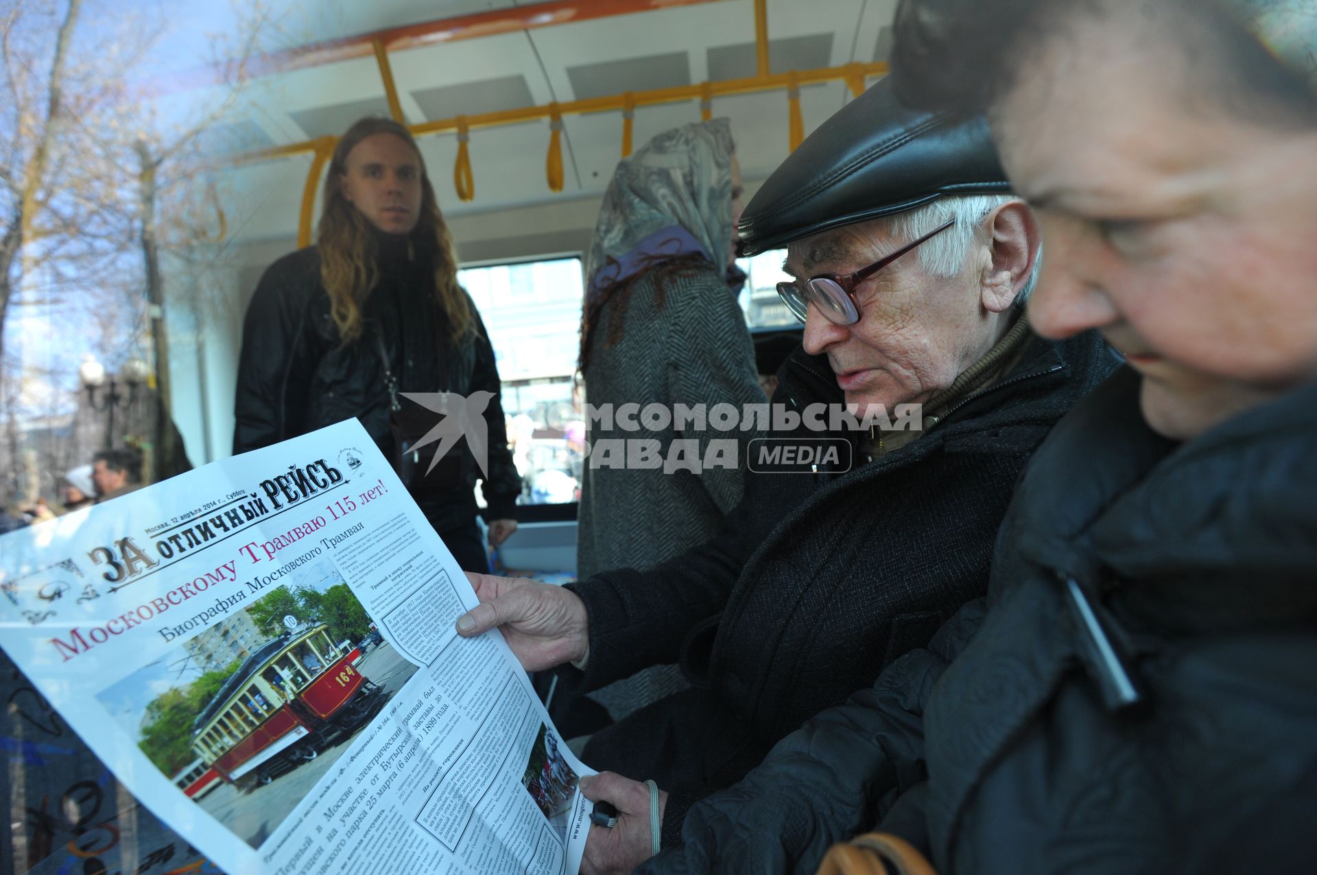 Праздничный парад трамваев, посвященный 115-летию этого вида транспорта. На снимке: пожилые мужчина и женщина читают газету.