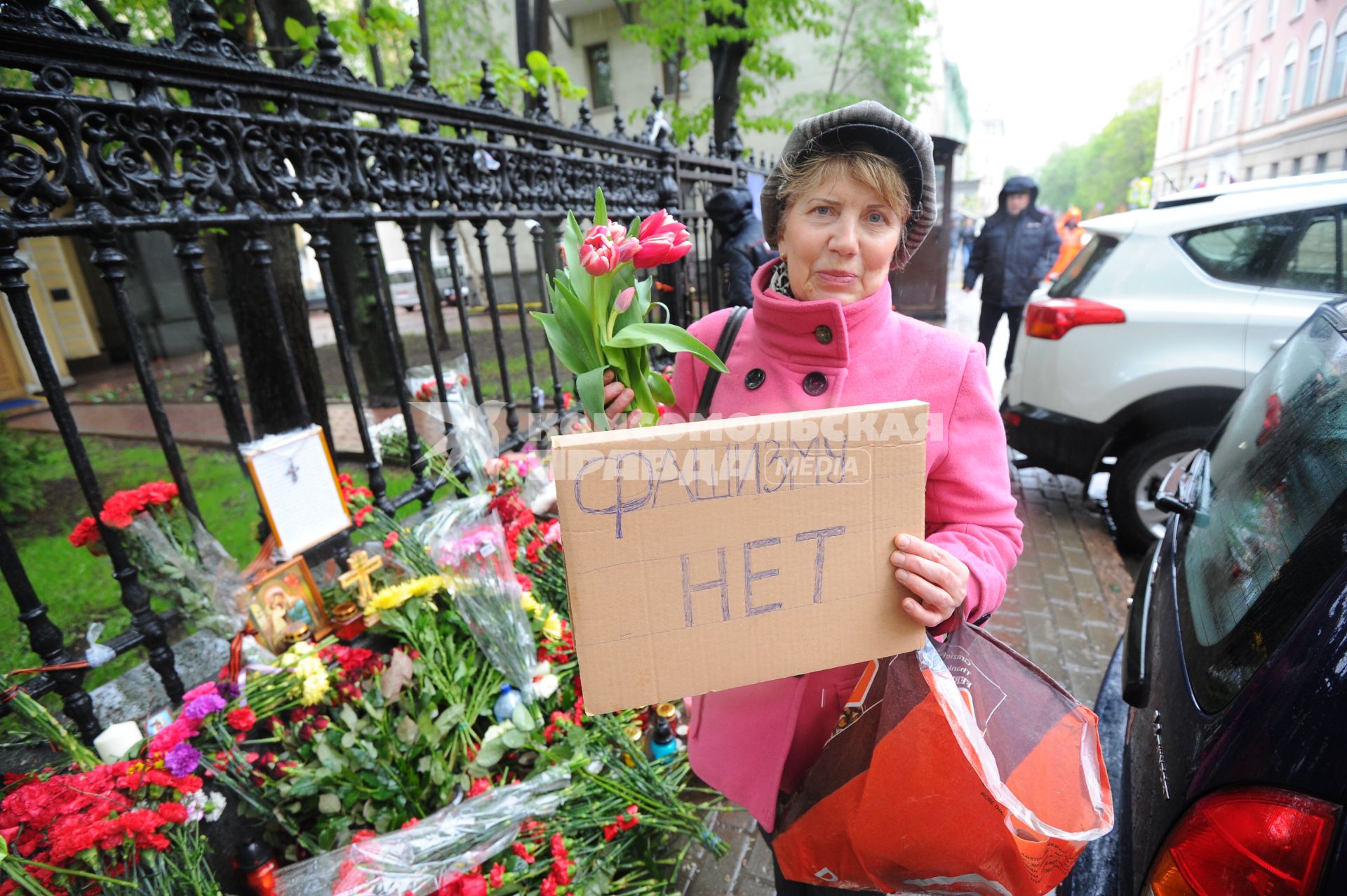 Акция памяти по погибшим в результате военных столкновений на Украине. Возложение цветов к зданию посольства Украины в Москве. На снимке: женщина с цветами и с табличкой `Фашизму нет`.