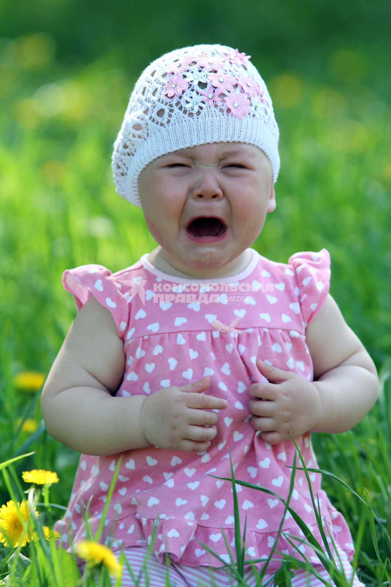 Девочка плачет летом в парке.