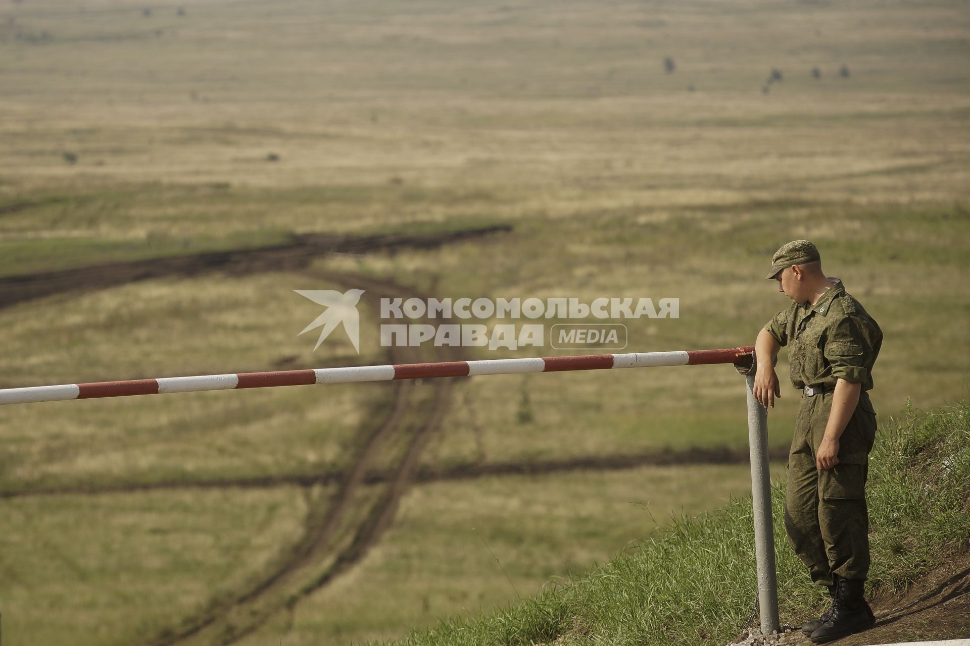 Российский военный стоит на посту облокотившись на шлакбаум на полигоне в Чебаркуле