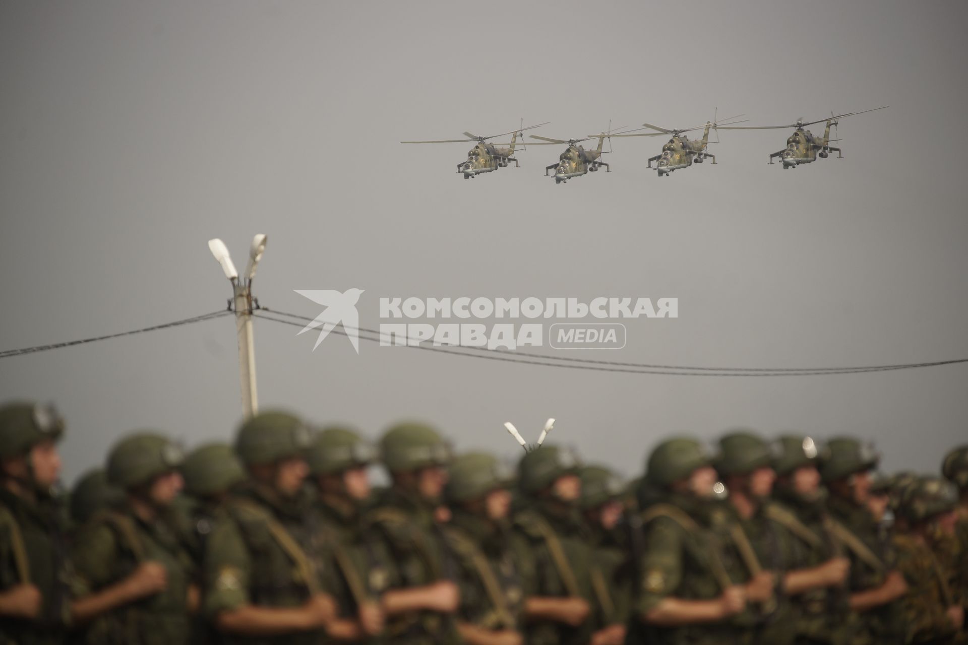 Российские боевые вертолеты ми-24 летят над строем Российских военный  во время проведения Российско-Китайских учений Мирная миссия 2013 на полигоне в Чебаркуле