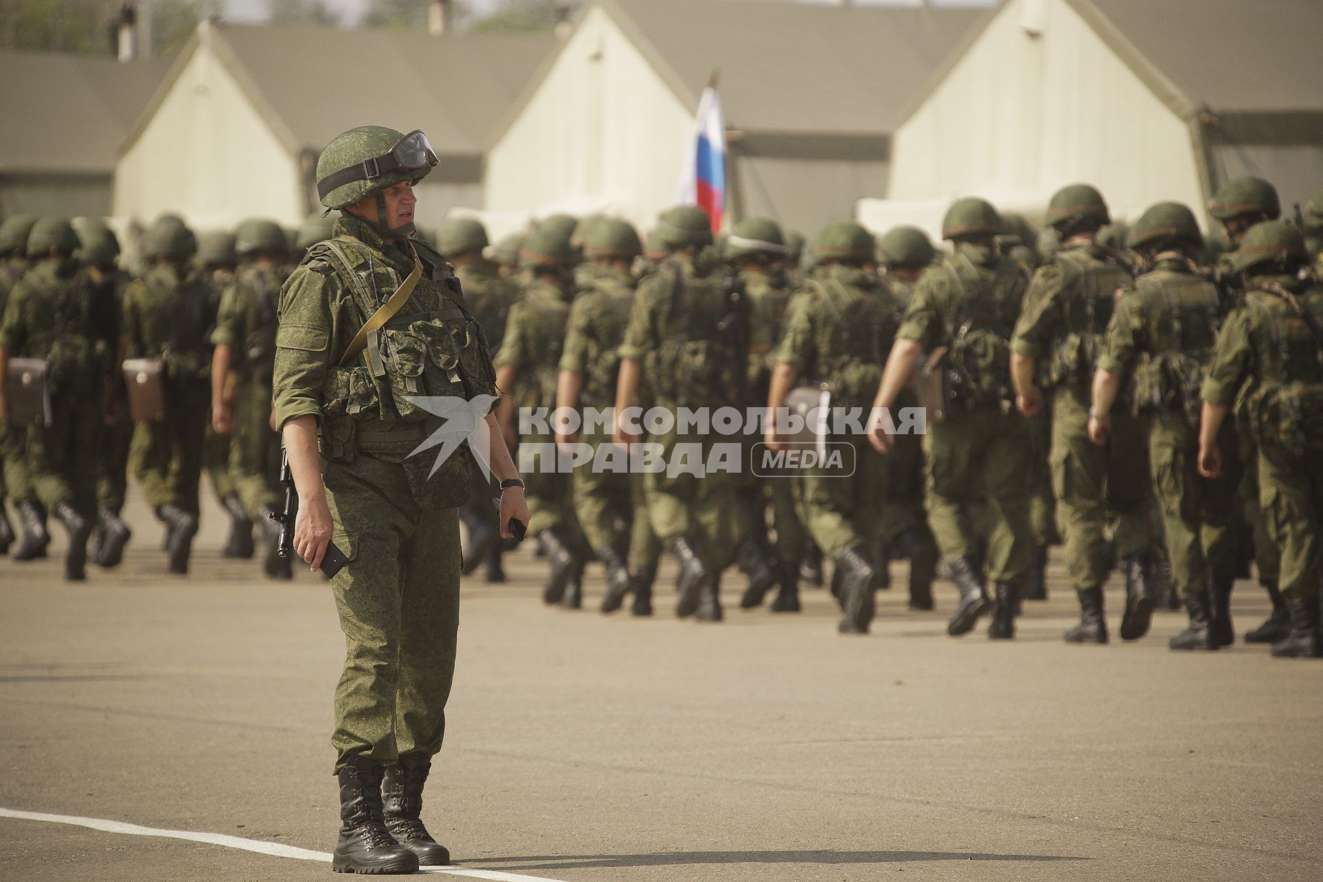 колонна российских солдат и офицер у палаточного лагеря во время проведения Российско-Китайских учений Мирная миссия 2013 на полигоне в Чебаркуле