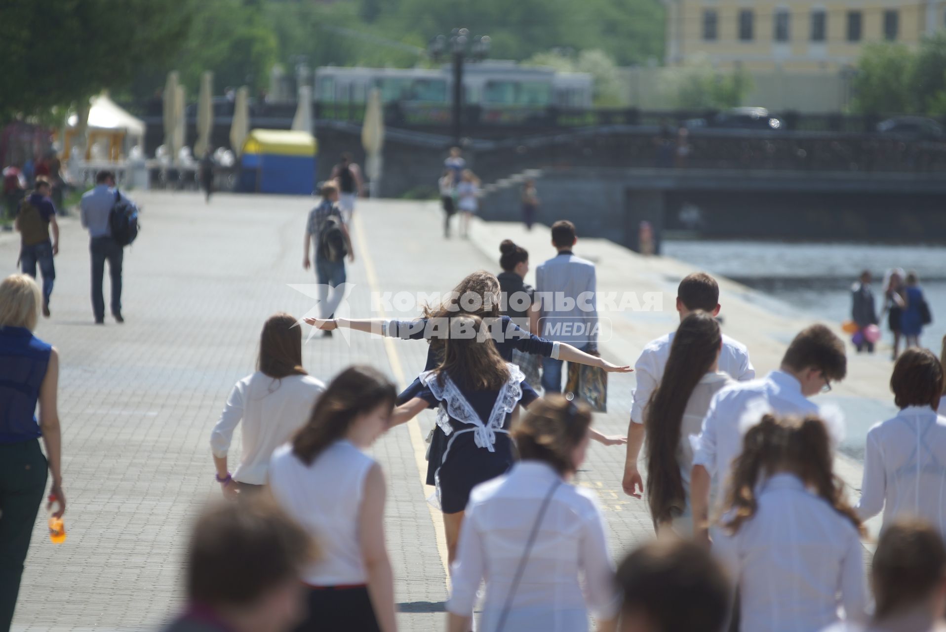 Выпускницы бегут по набережной  во время празднования последнего звонка в школах