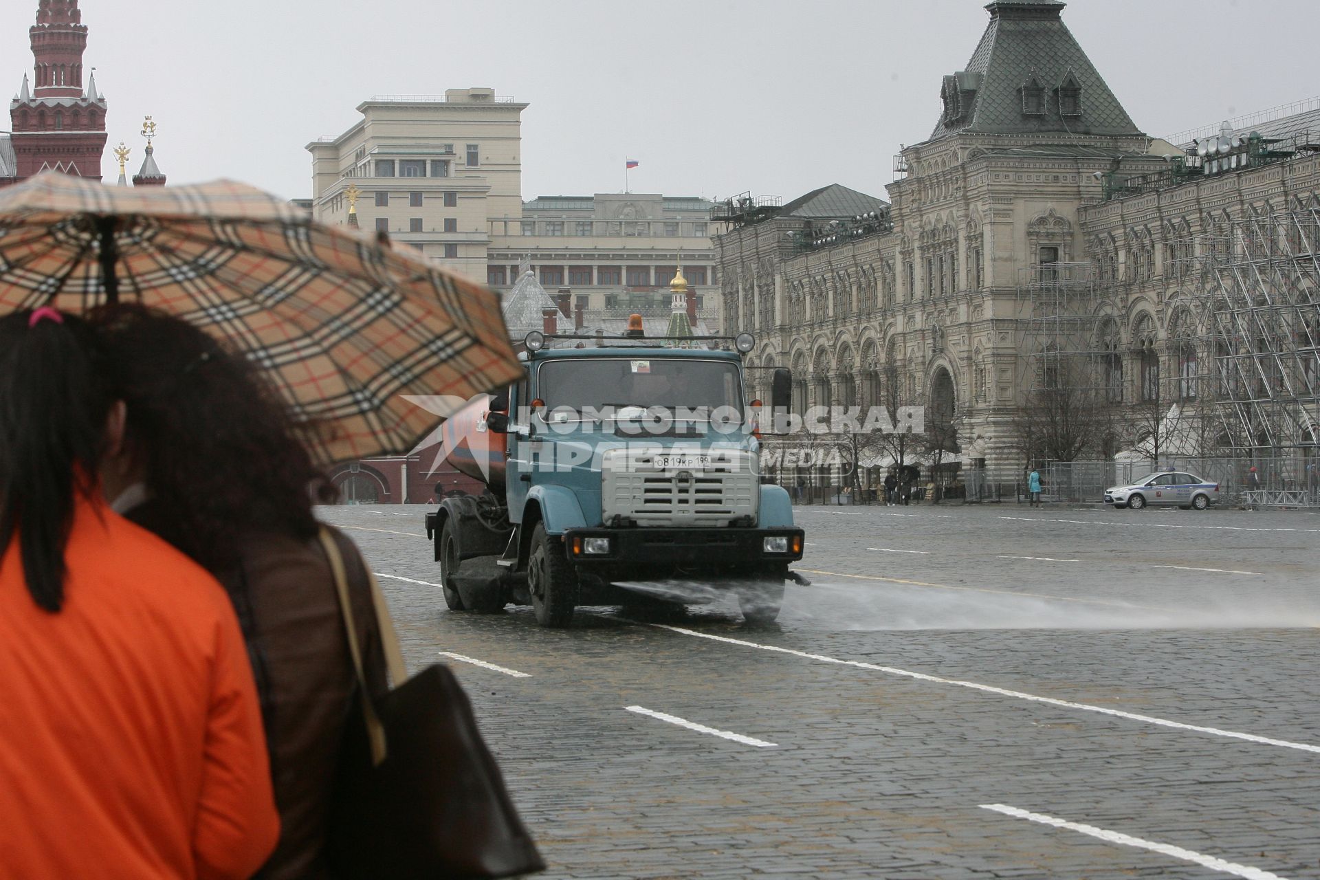 Красная площадь. На снимке: поливальная машина и люди под зонтом.