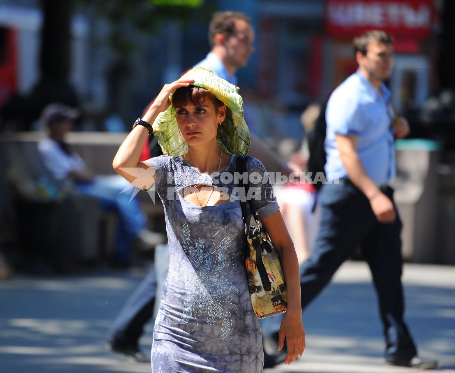 Жара в Москве. На снимке: девушка идет по улице с платком на голове.