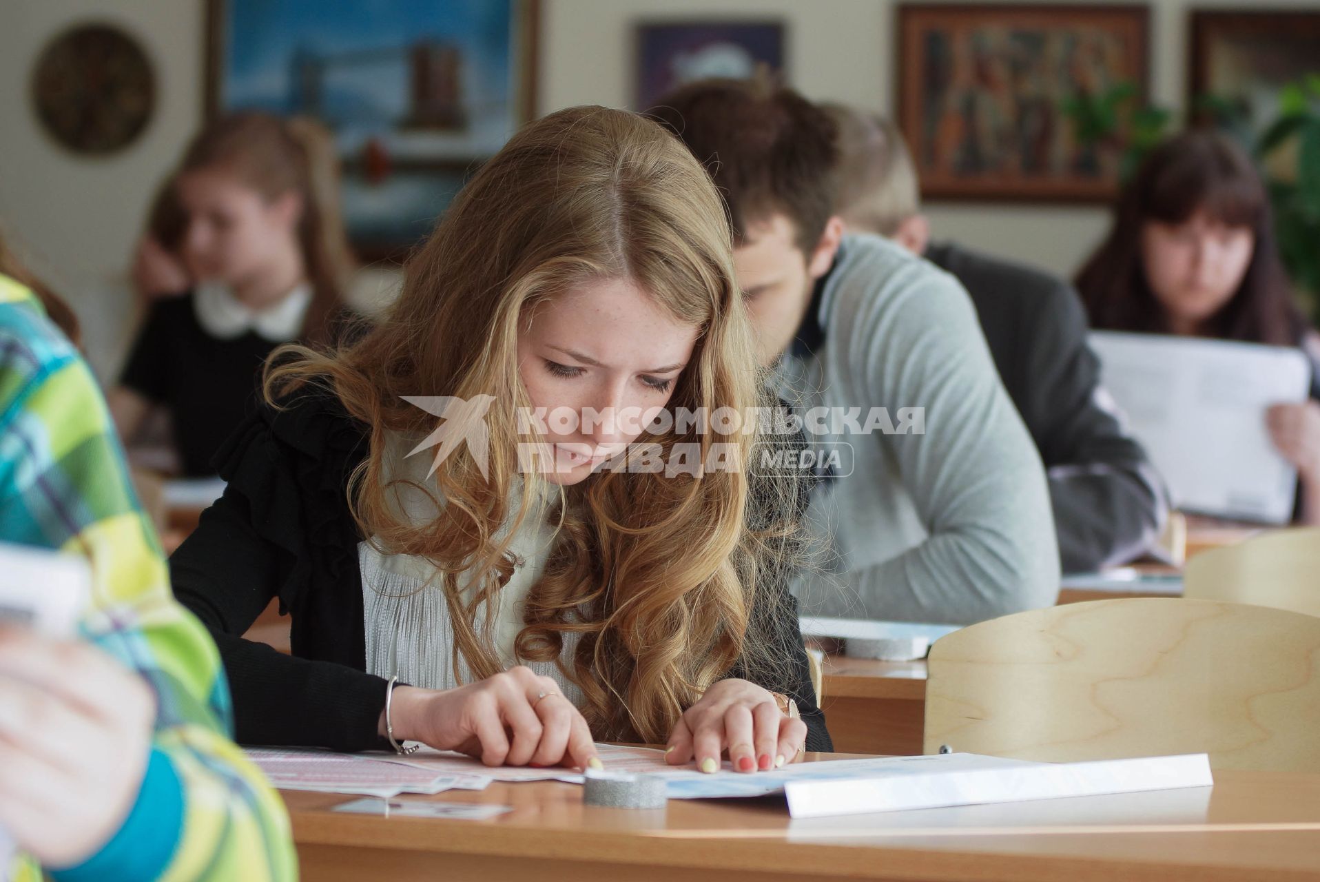 Школьники заполняют экзаменационные бланки во время сдачи ЕГЭ
