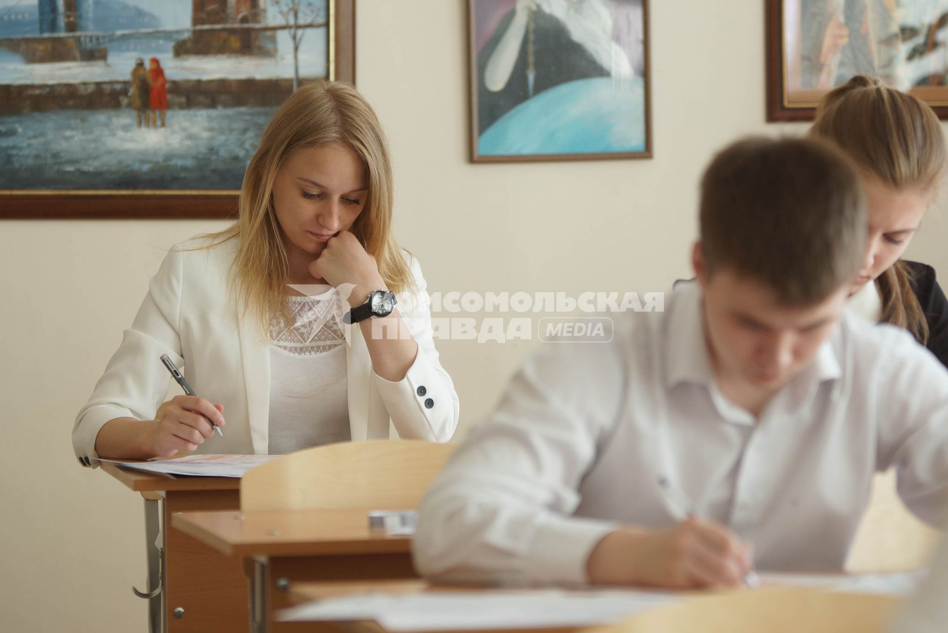 Школьники заполняют экзаменационные бланки во время сдачи ЕГЭ