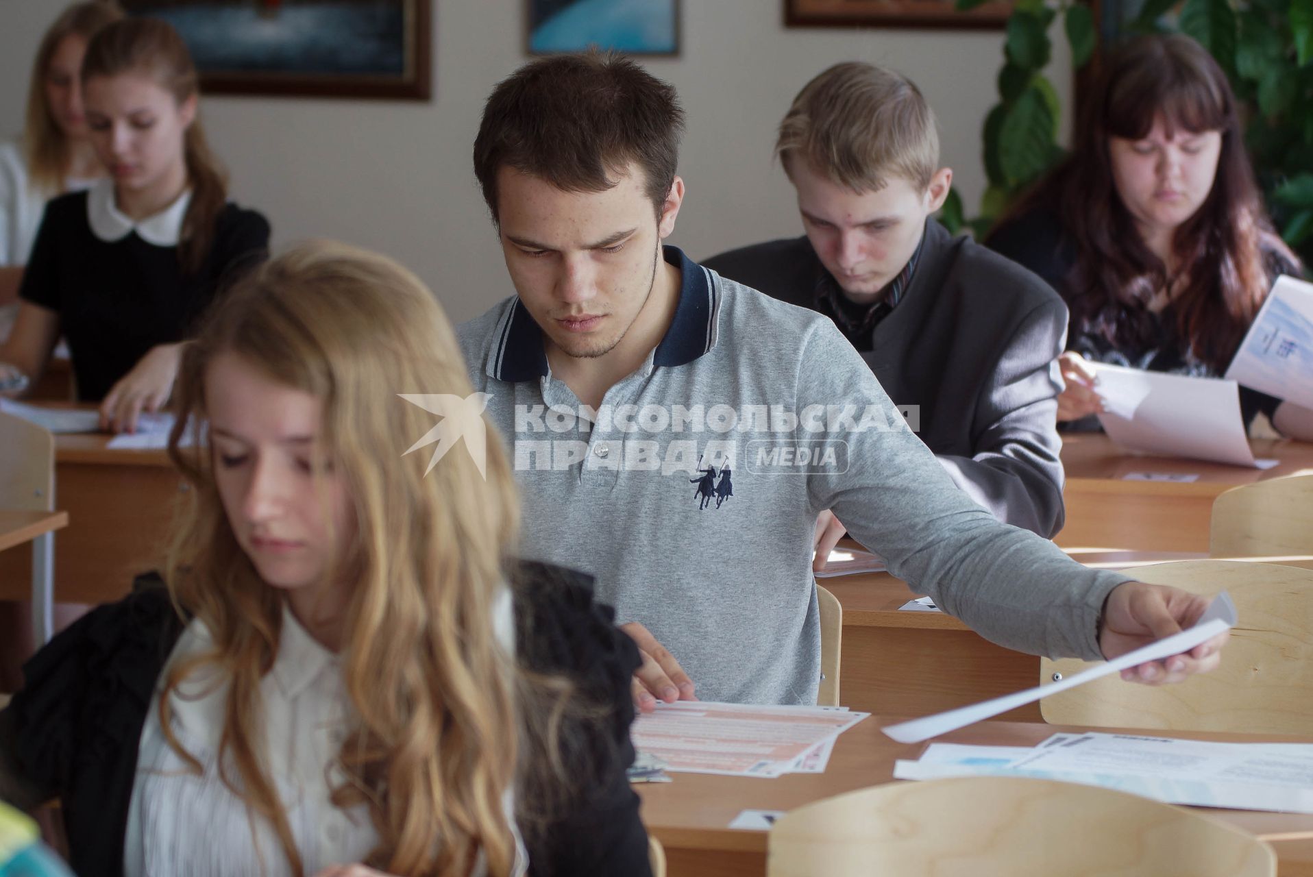 Школьники заполняют экзаменационные бланки во время сдачи ЕГЭ